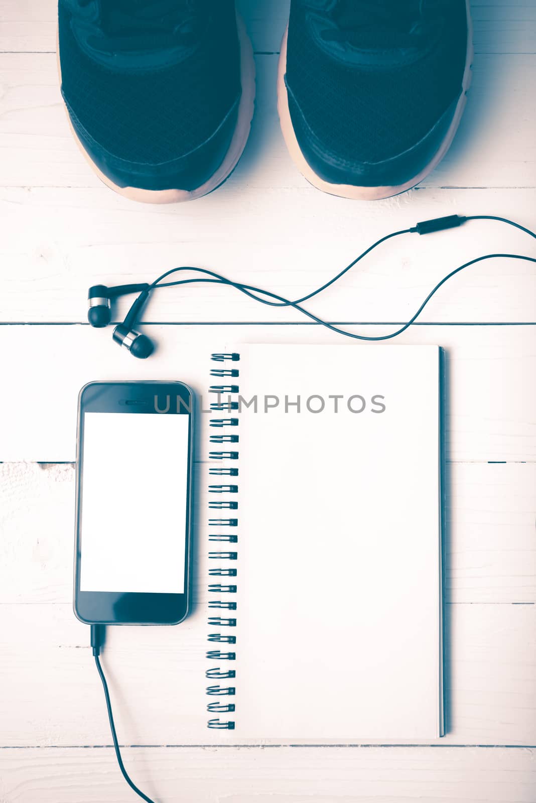 running shoes,notebook and phone on white wood table vintage style