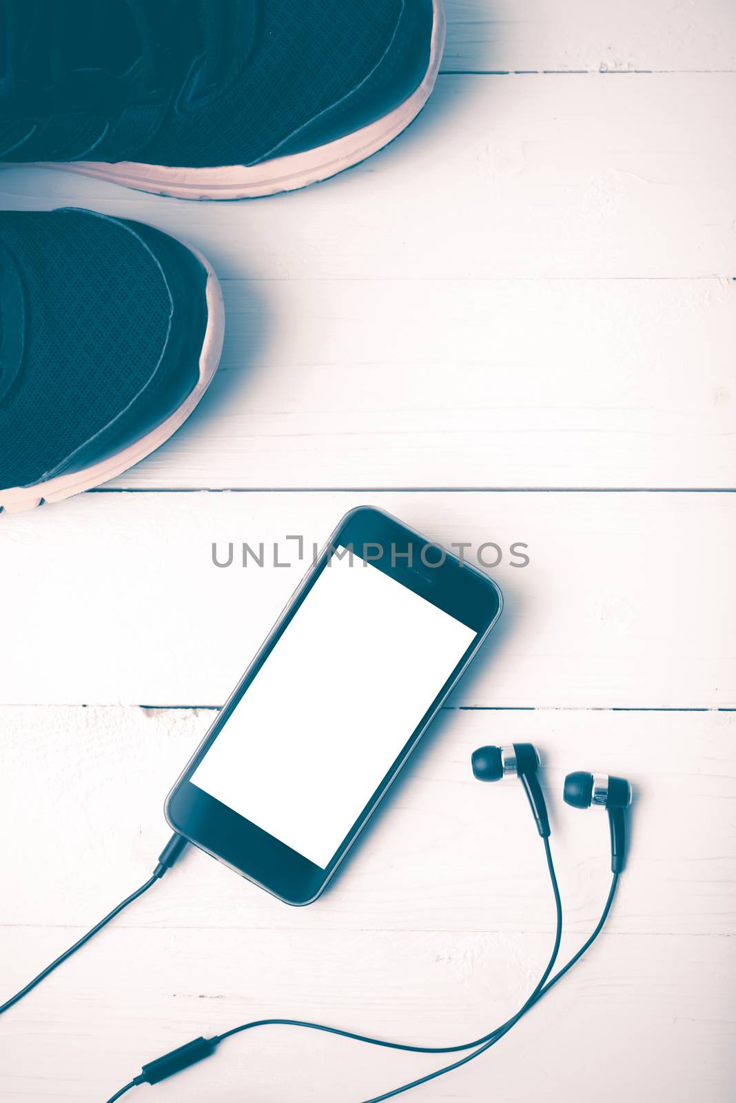 running shoes and phone on white wood table vintage style