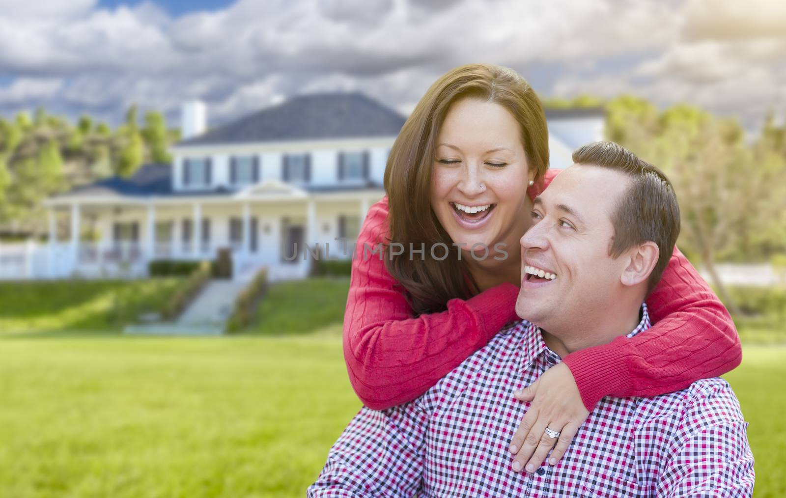 Happy Affectionate Laughing Couple Outdoors In Front of Beautiful House.