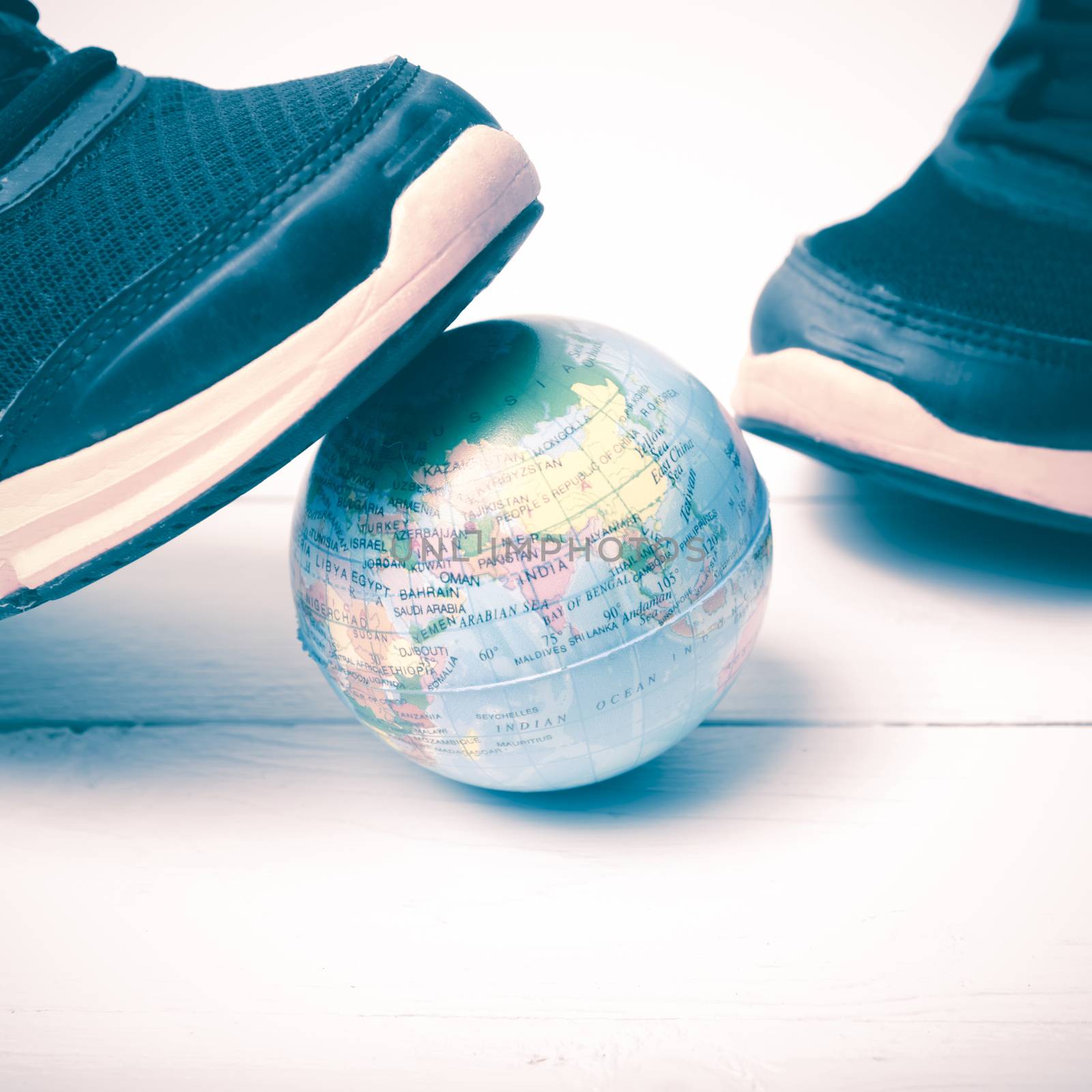 running shoes and earth ball on white wood table concept world healthy vintage style