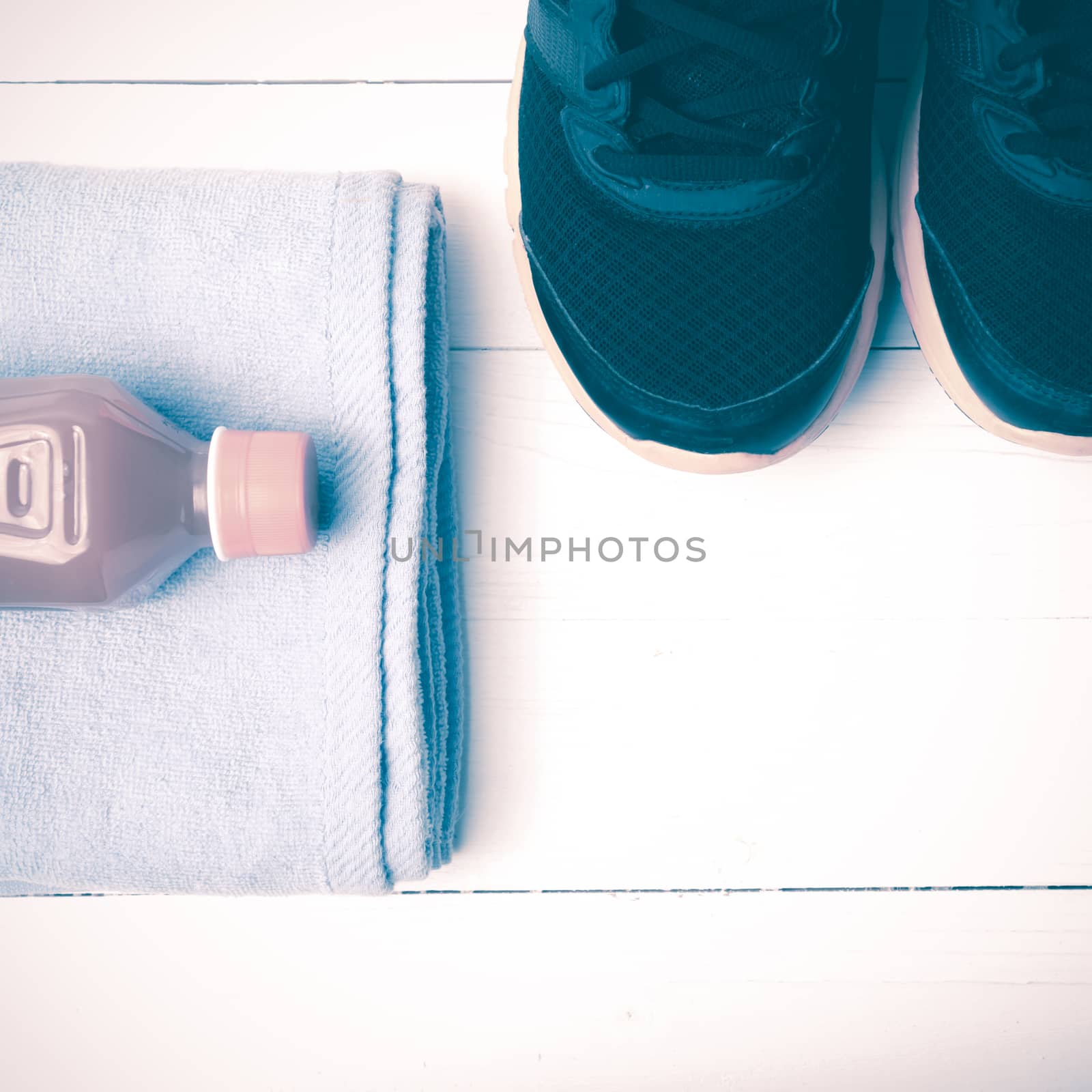 running shoes,towel and orange juice on white wood table vintage style