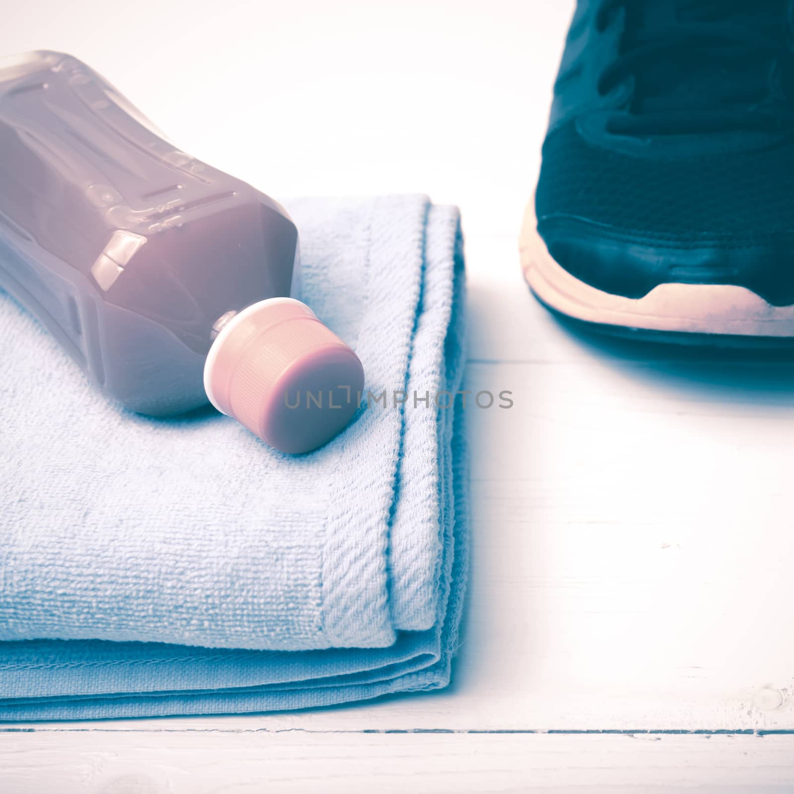 running shoes,towel and orange juice on white wood table vintage style