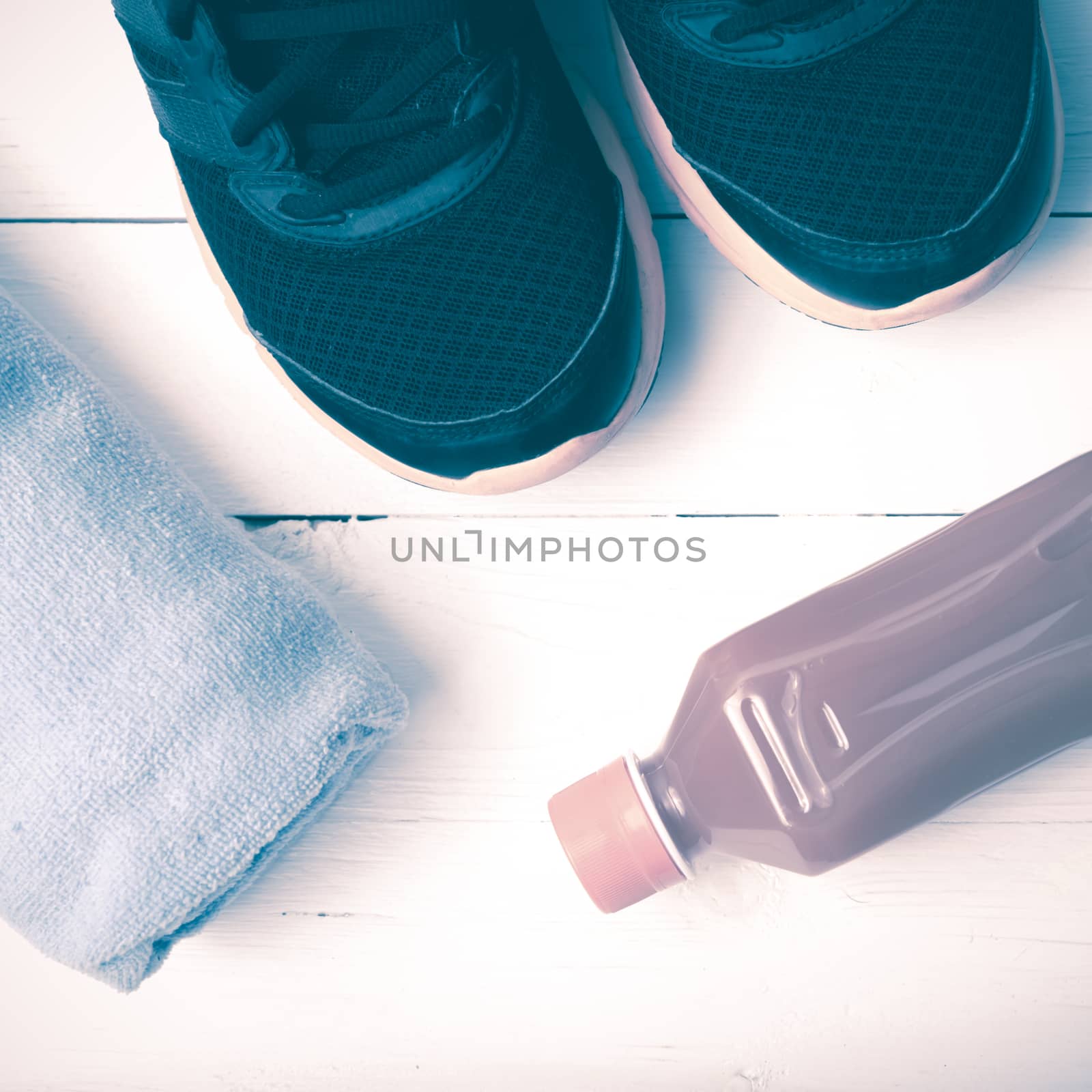 running shoes,towel and orange juice on white wood table vintage style