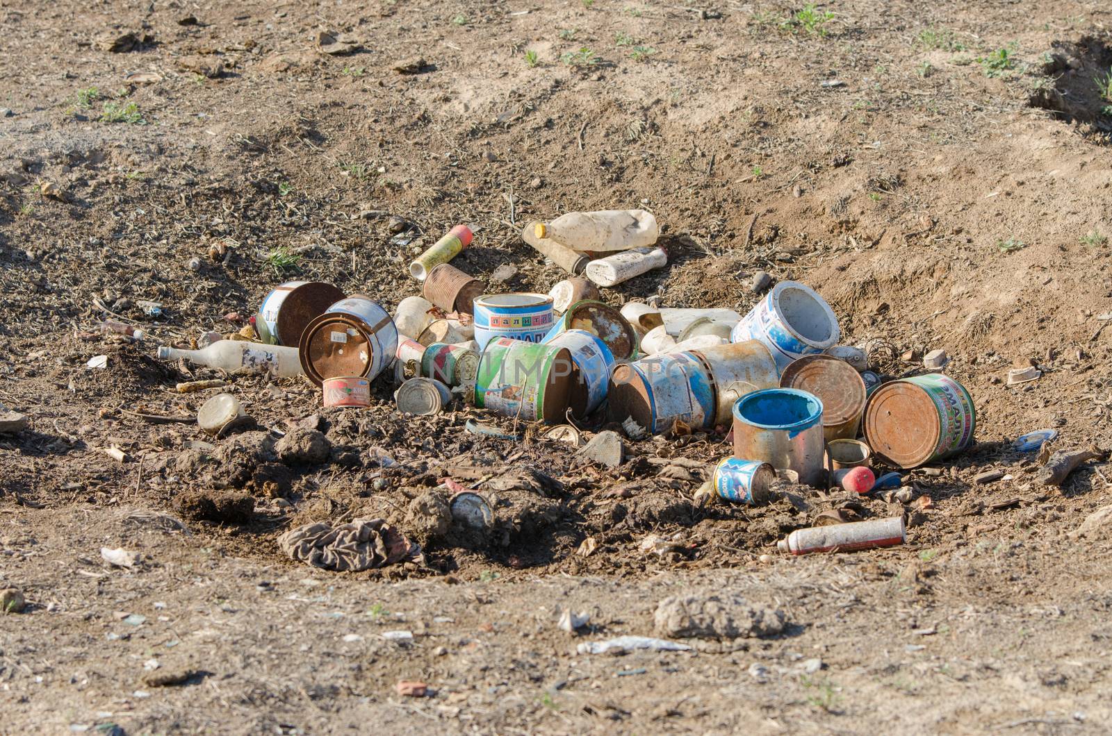 Solodniki, Russia - May 13, 2015: A bunch of old debris, empty paint cans and household waste is in the earth pit