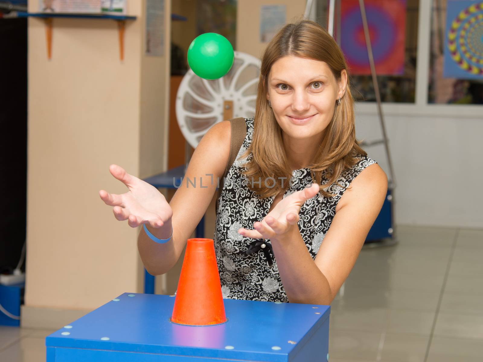 Volgograd, Russia - August 31, 2015: A girl holding hands under a flying ball - entertaining science museum exhibit Einstein in Volgograd