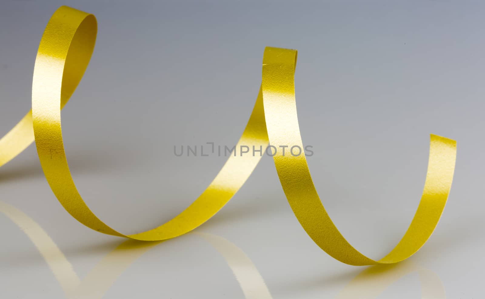 Gold Ribbon String close up on grey/white background.