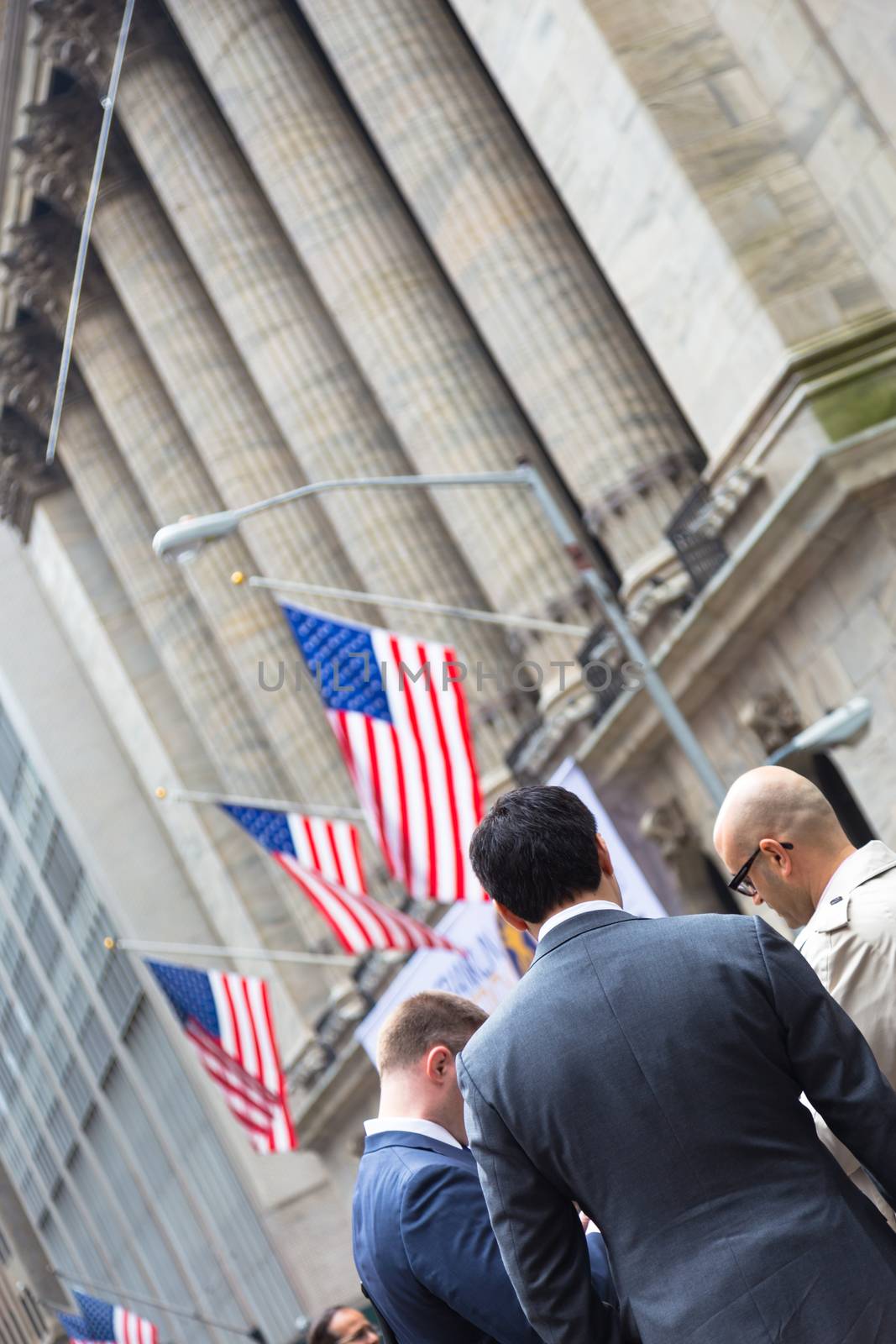 New York City, United States of America - March 26: Businessmen talking on Wall street in front of New York Stock Exchange on March 26, 2015.