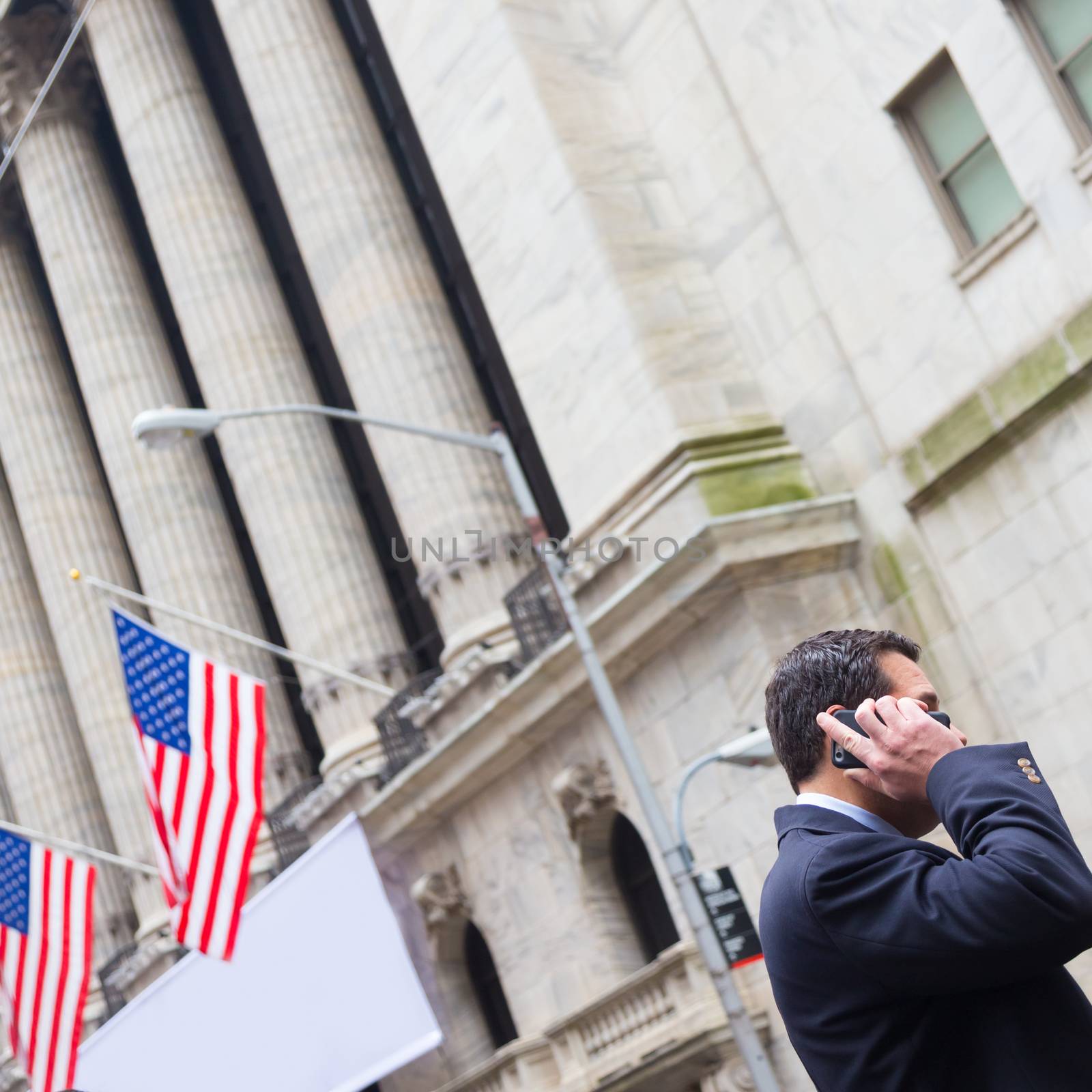 New York City, United States of America - March 26: Businessman talking on phone on Wall street in front of New York Stock Exchange on March 26, 2015.