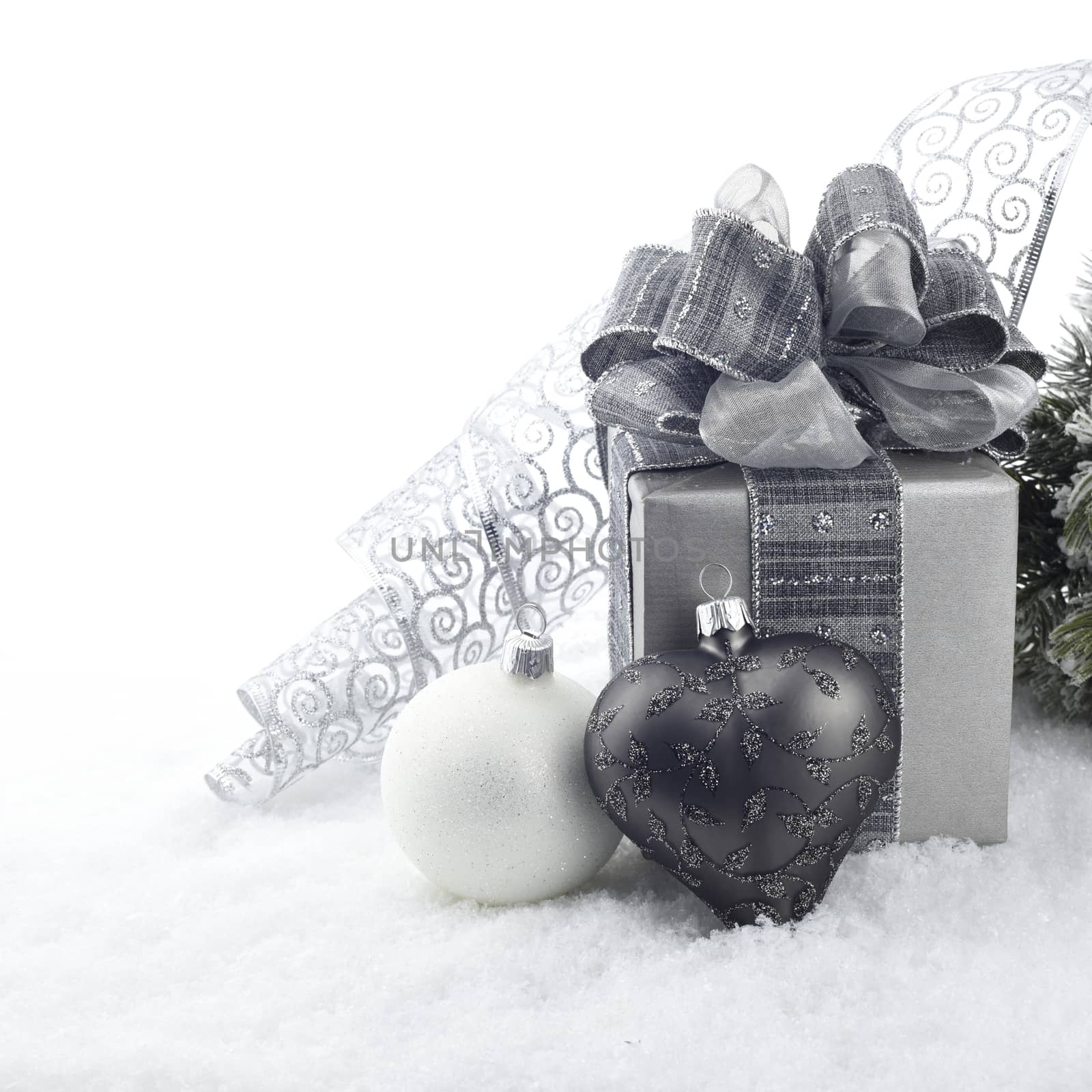 Christmas decoration with ball ornaments and gift box on snow