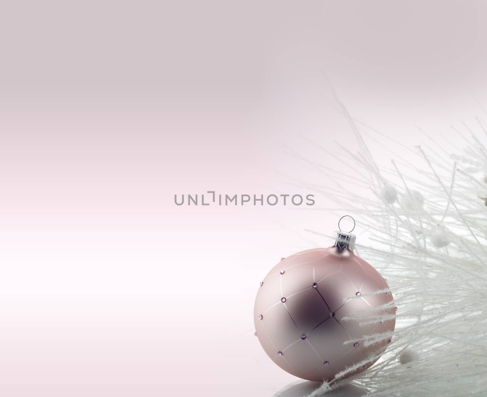 Christmas decoration with ball ornament over pale pink  background