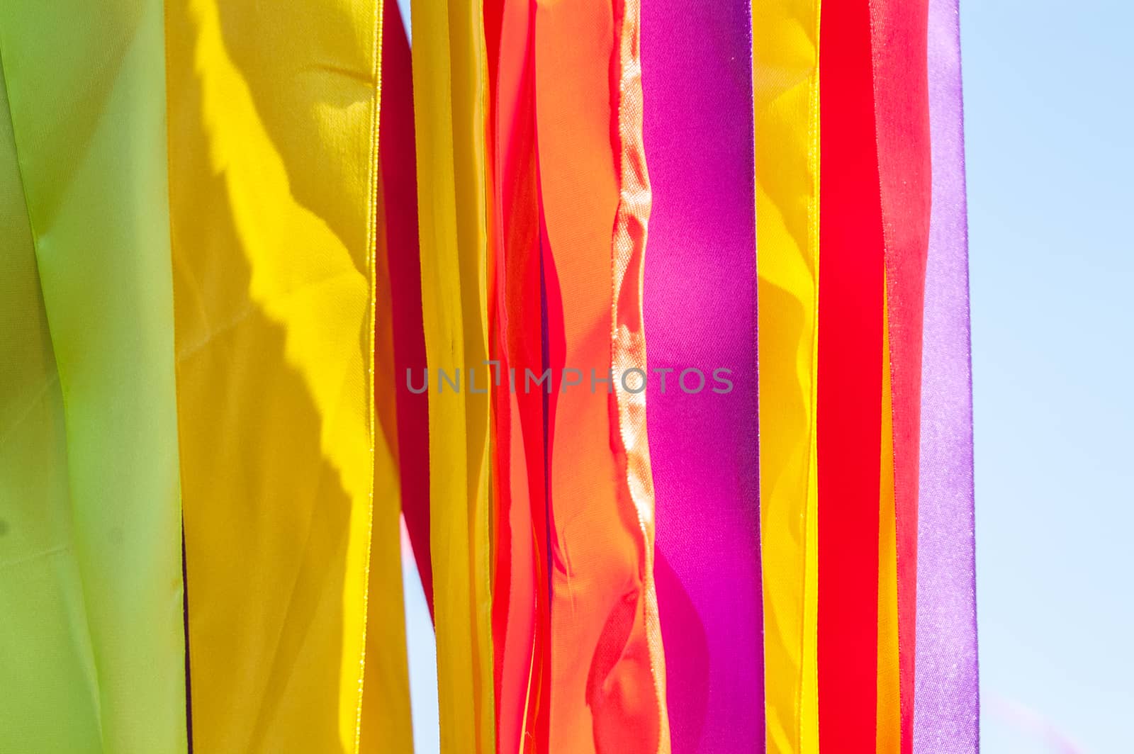 Multi-colored strips of tapes on a wind in the sunny summer day