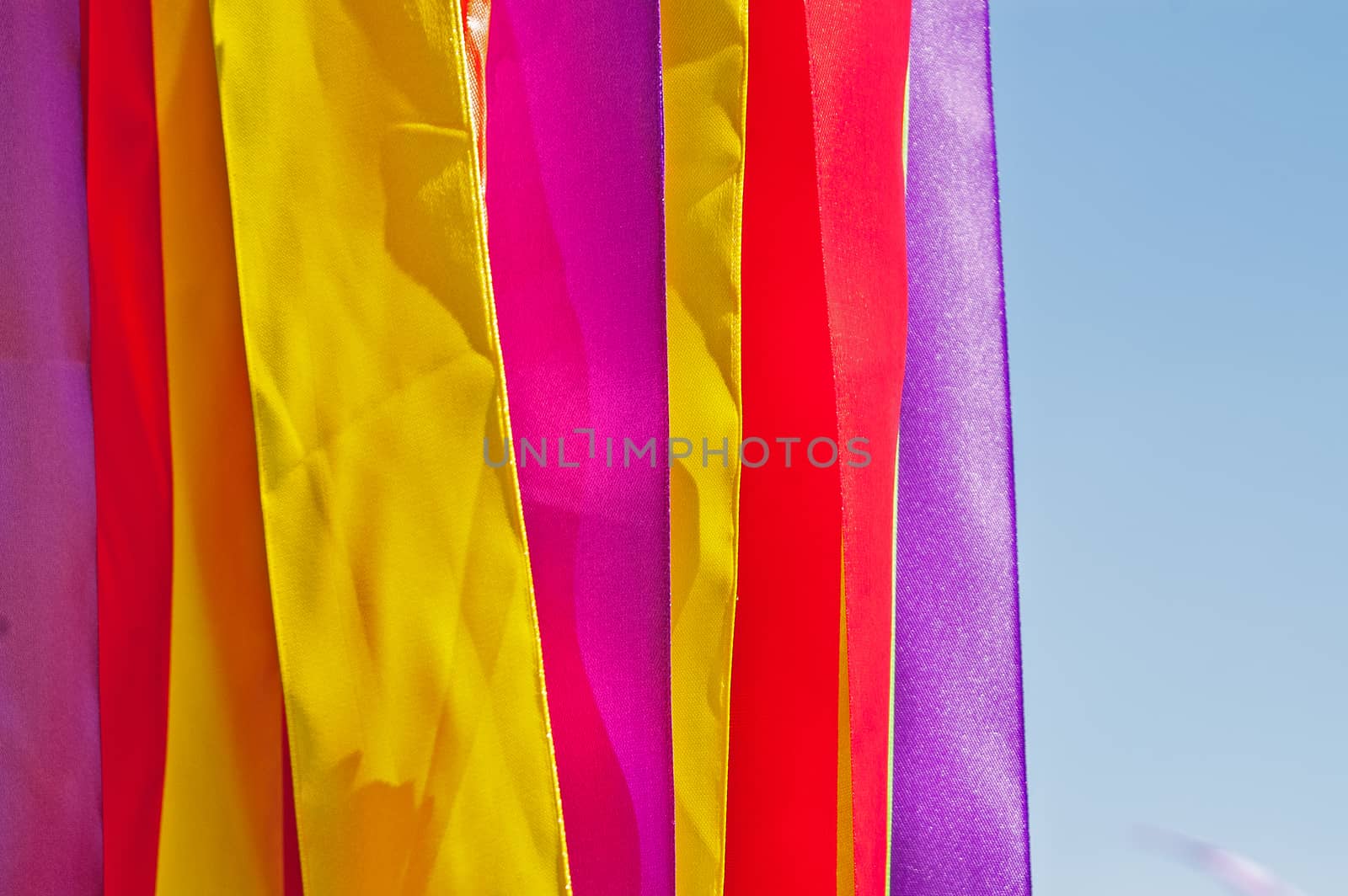 Multi-colored strips of tapes on a wind in the sunny summer day