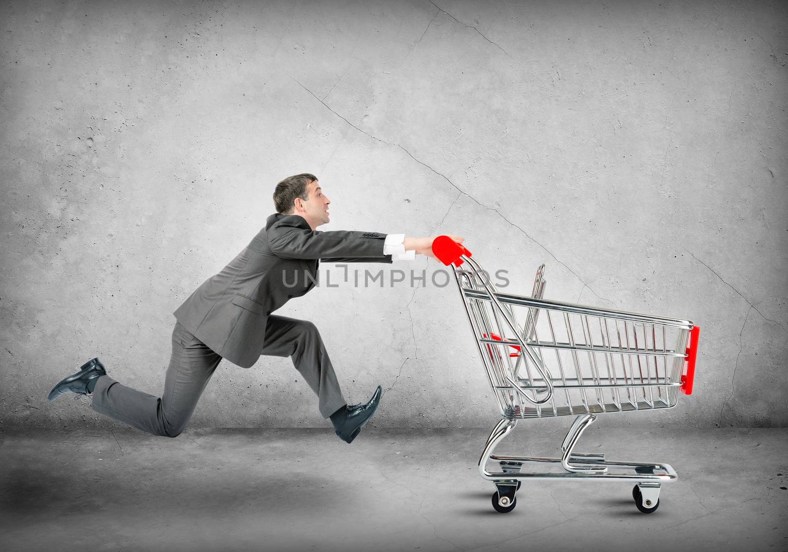 Businessman pushing shopping cart  by cherezoff