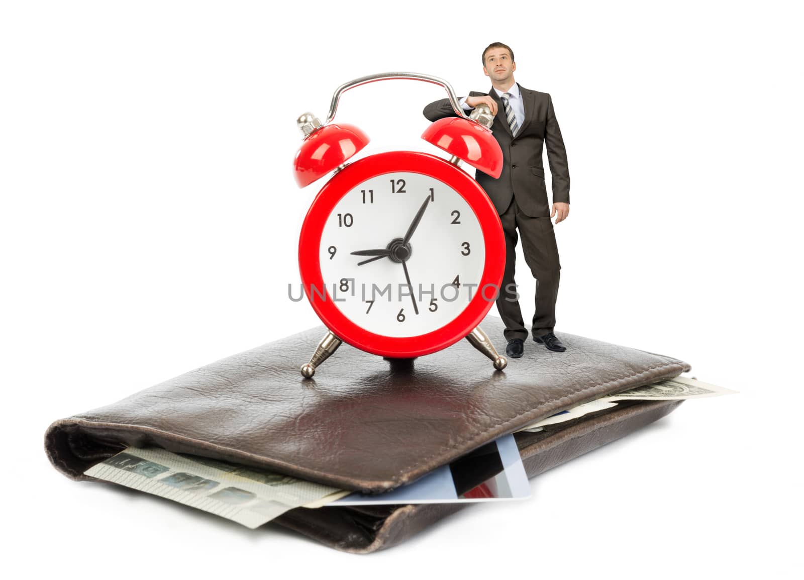 Businessman standing on purse with alarm clock on isolated white background
