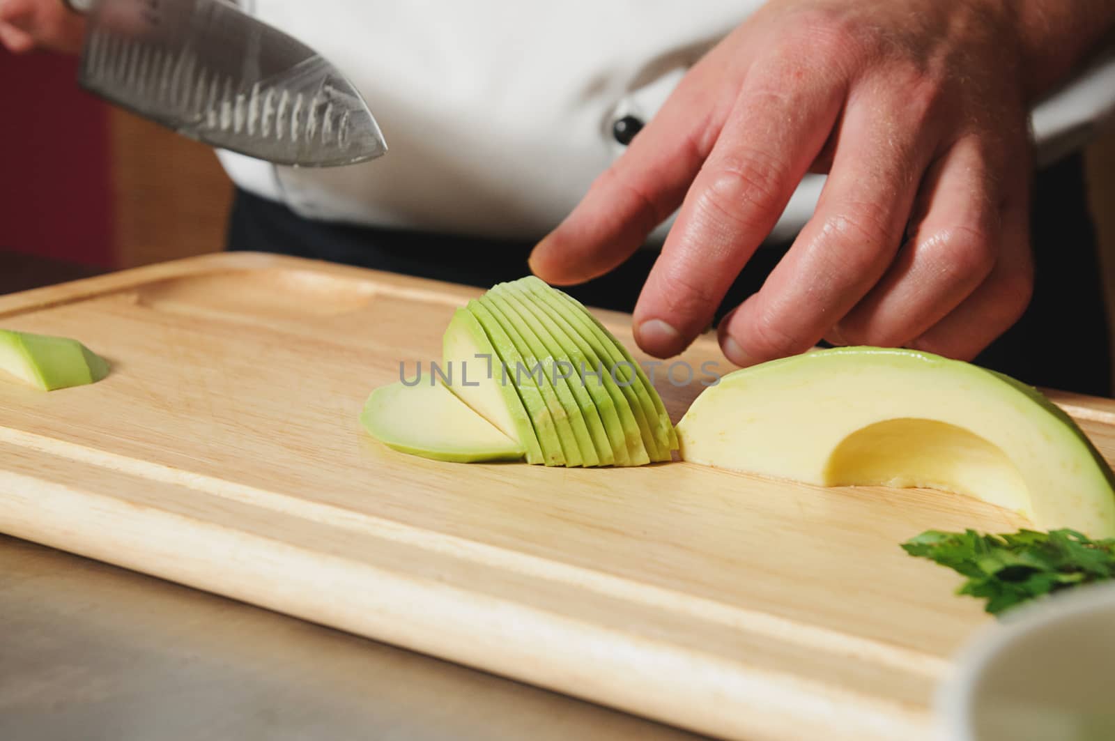 chef cutting lavocado on table with knife