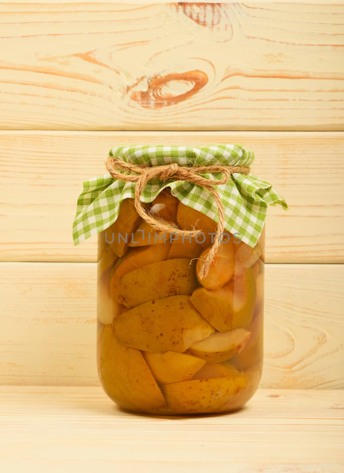 One jar of pear compote at beige vintage wood surface by BreakingTheWalls