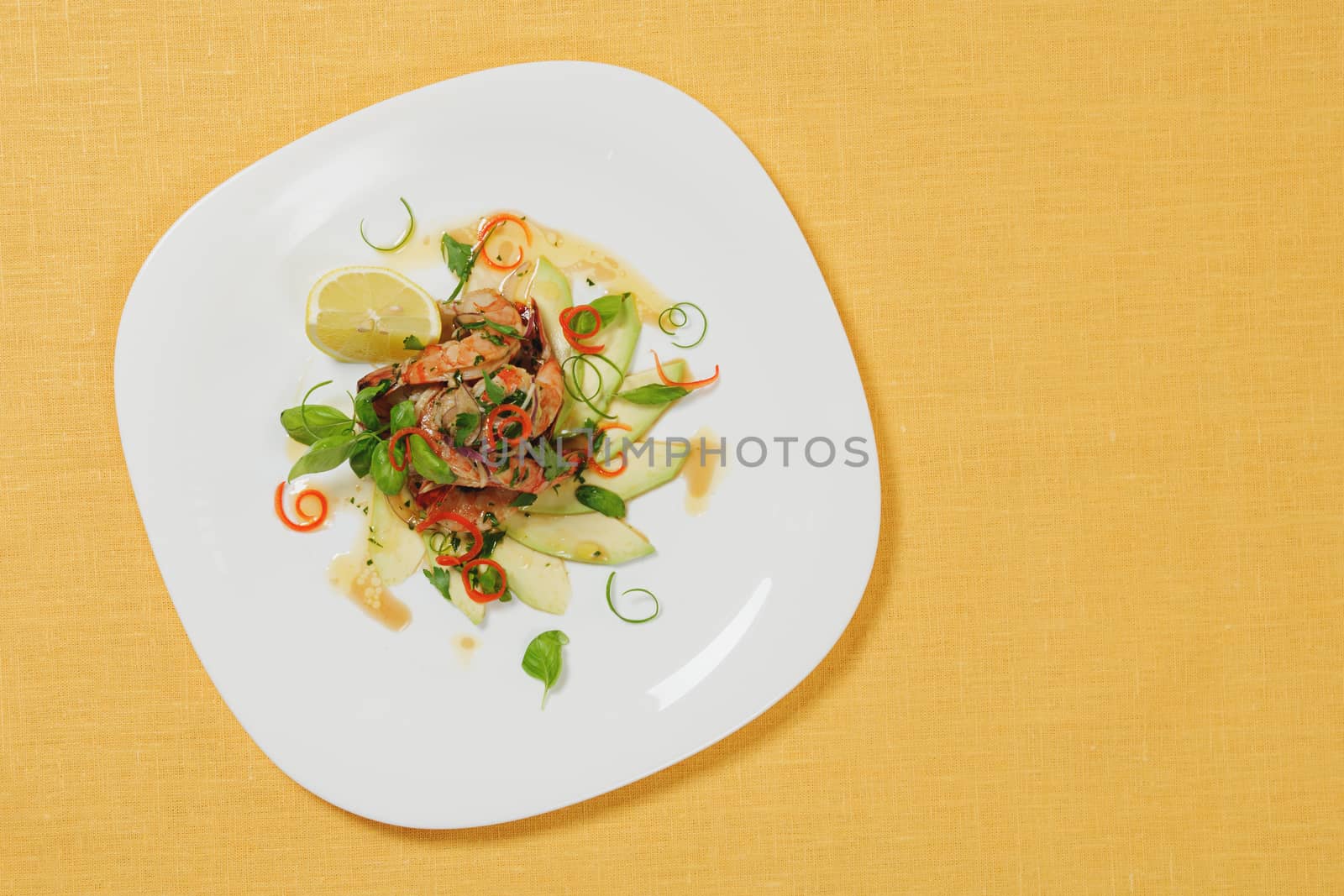 Seafood salade on white plate with shripms and avocado