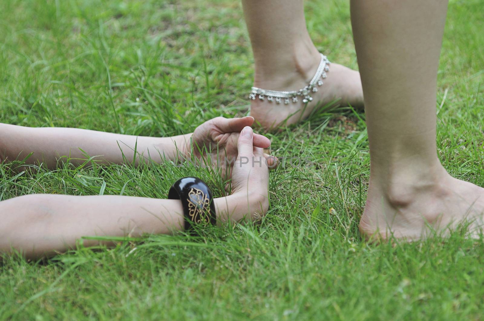 Close up of yoga pose in grass by dimarik