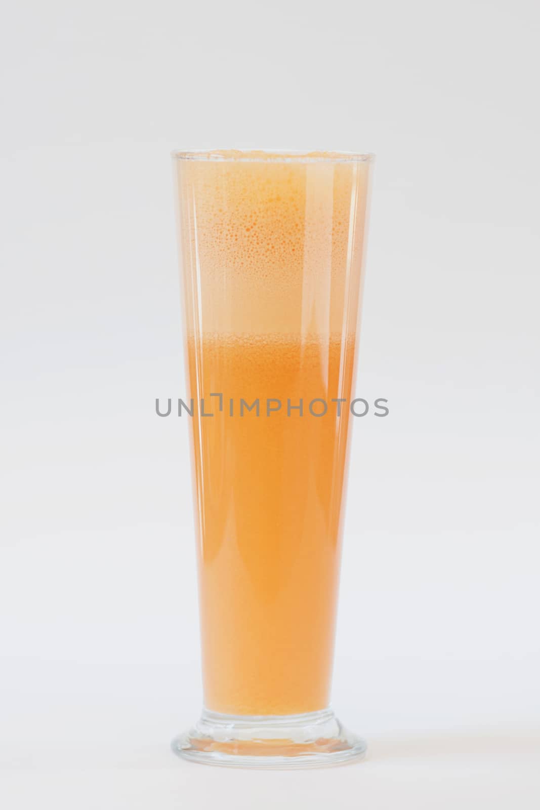 smoothie orange colour in tall glass on white background