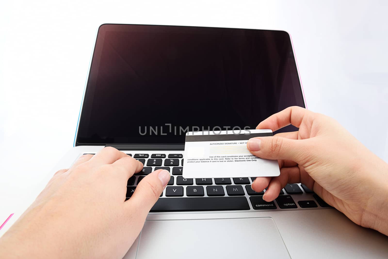 view from eye level of Human next to laptop with credit card on white background