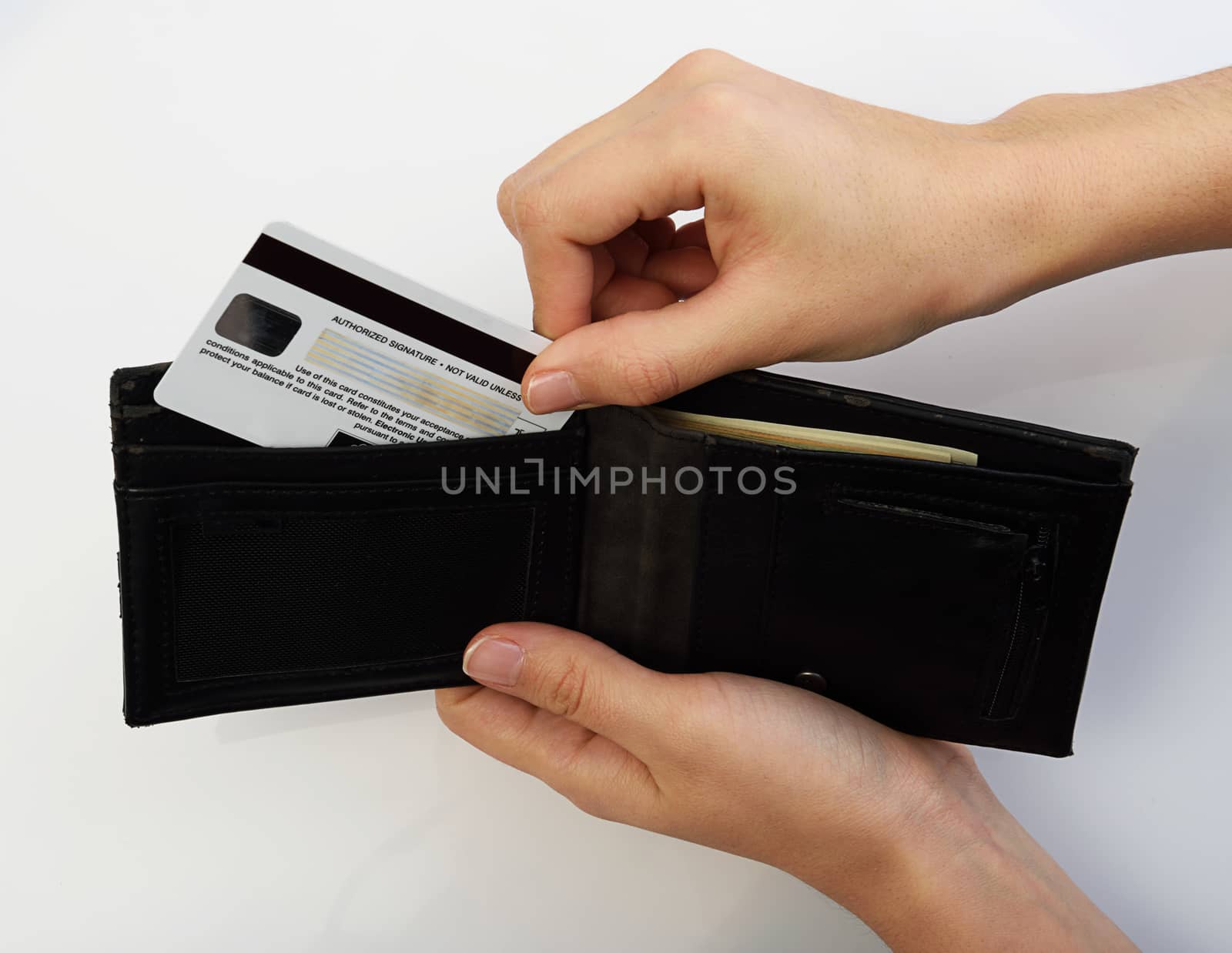 Person taking credit card from black wallet on white backdrop