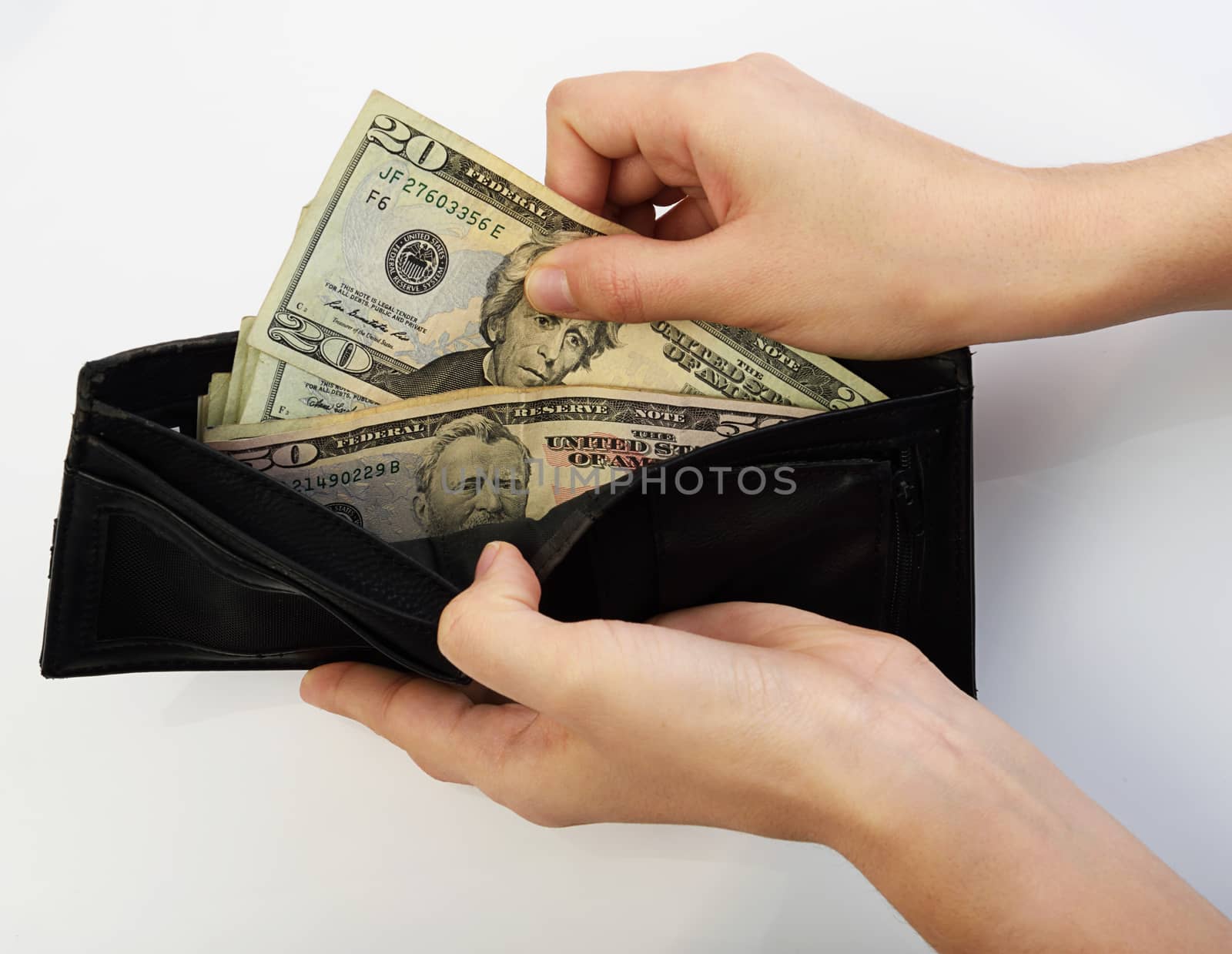 Person taking twenty dollars money from black wallet