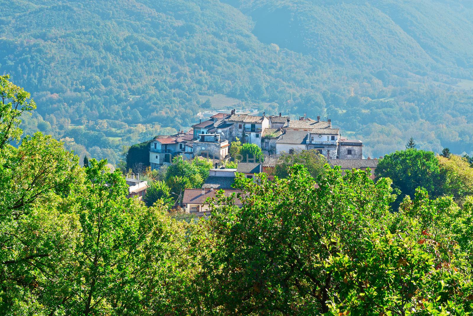 Medieval Italian City on a Hilltop Surrounded by Mountains Covered with Forests