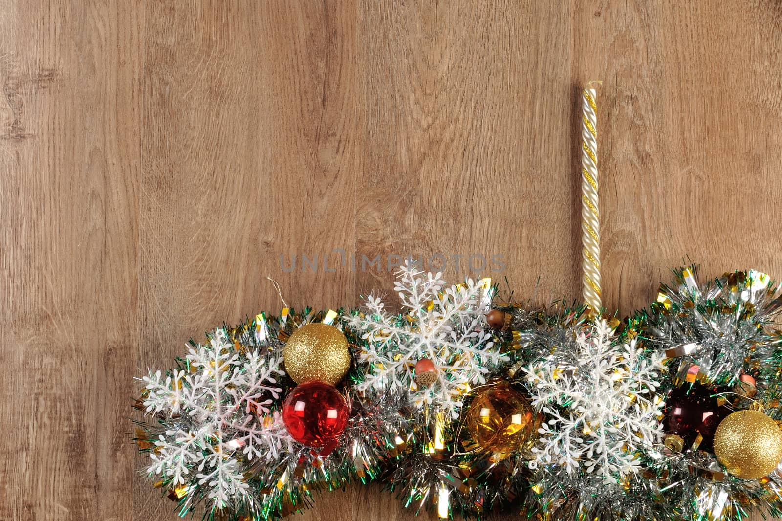 christmas balls and candle on wood floor