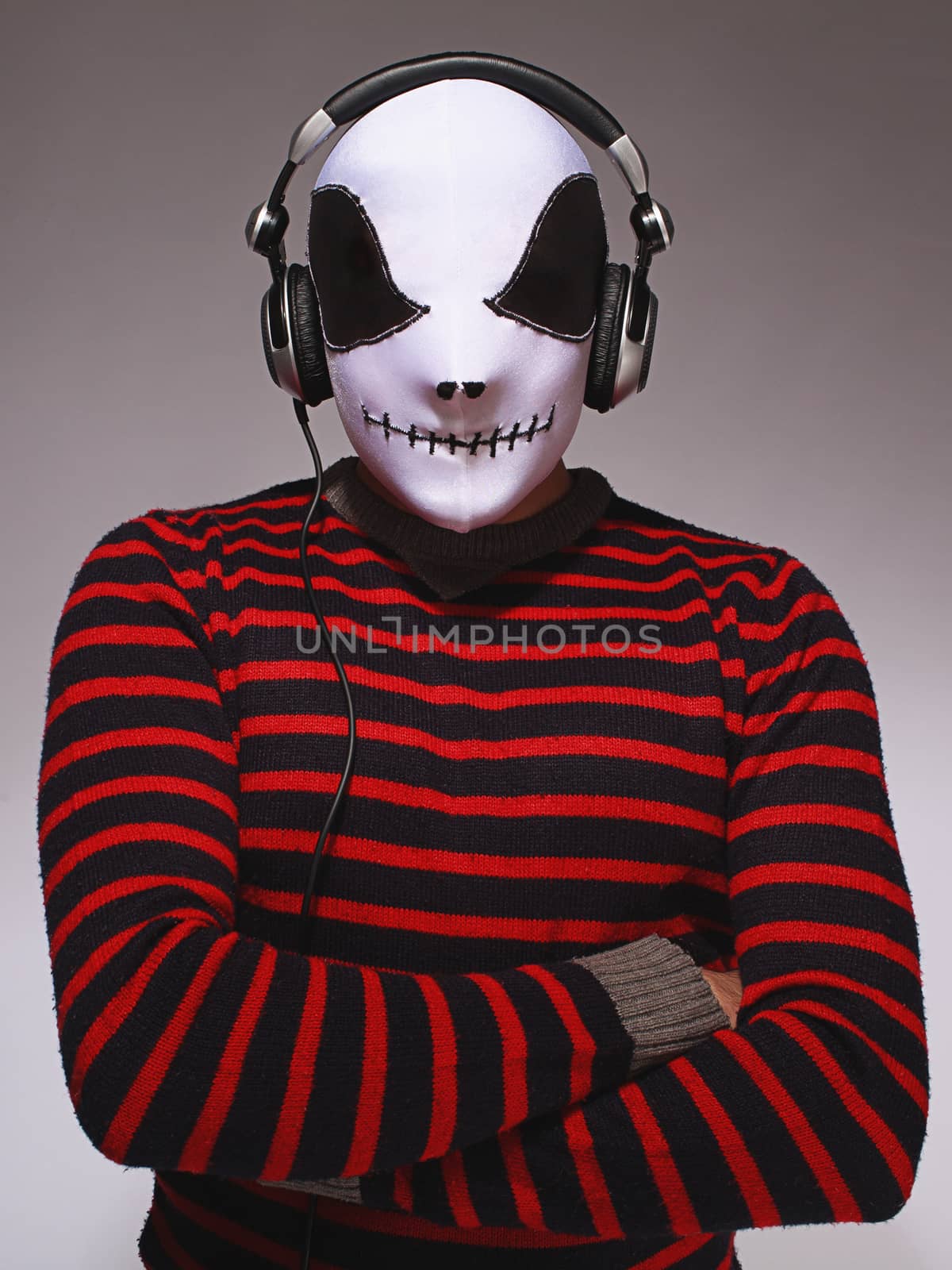 Dj wearing mask and headphones on grey background