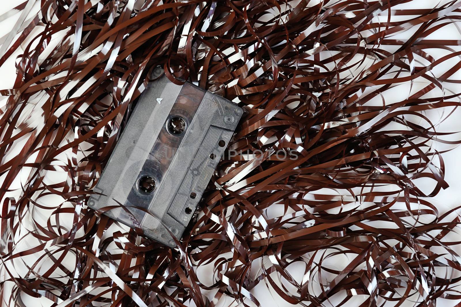 Audio casette on top of tape on a white background