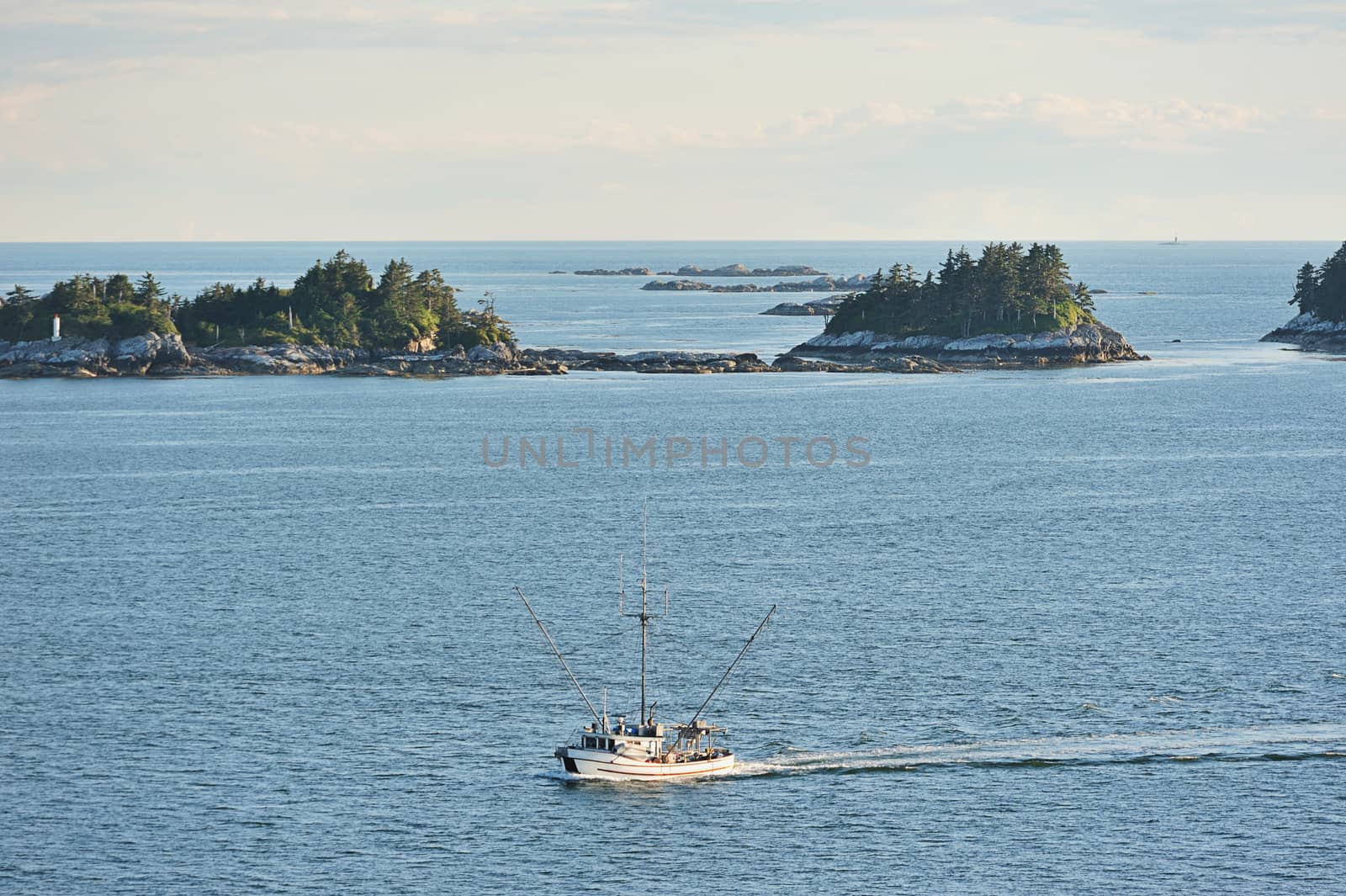 Fishboat moving next to islands and rocks