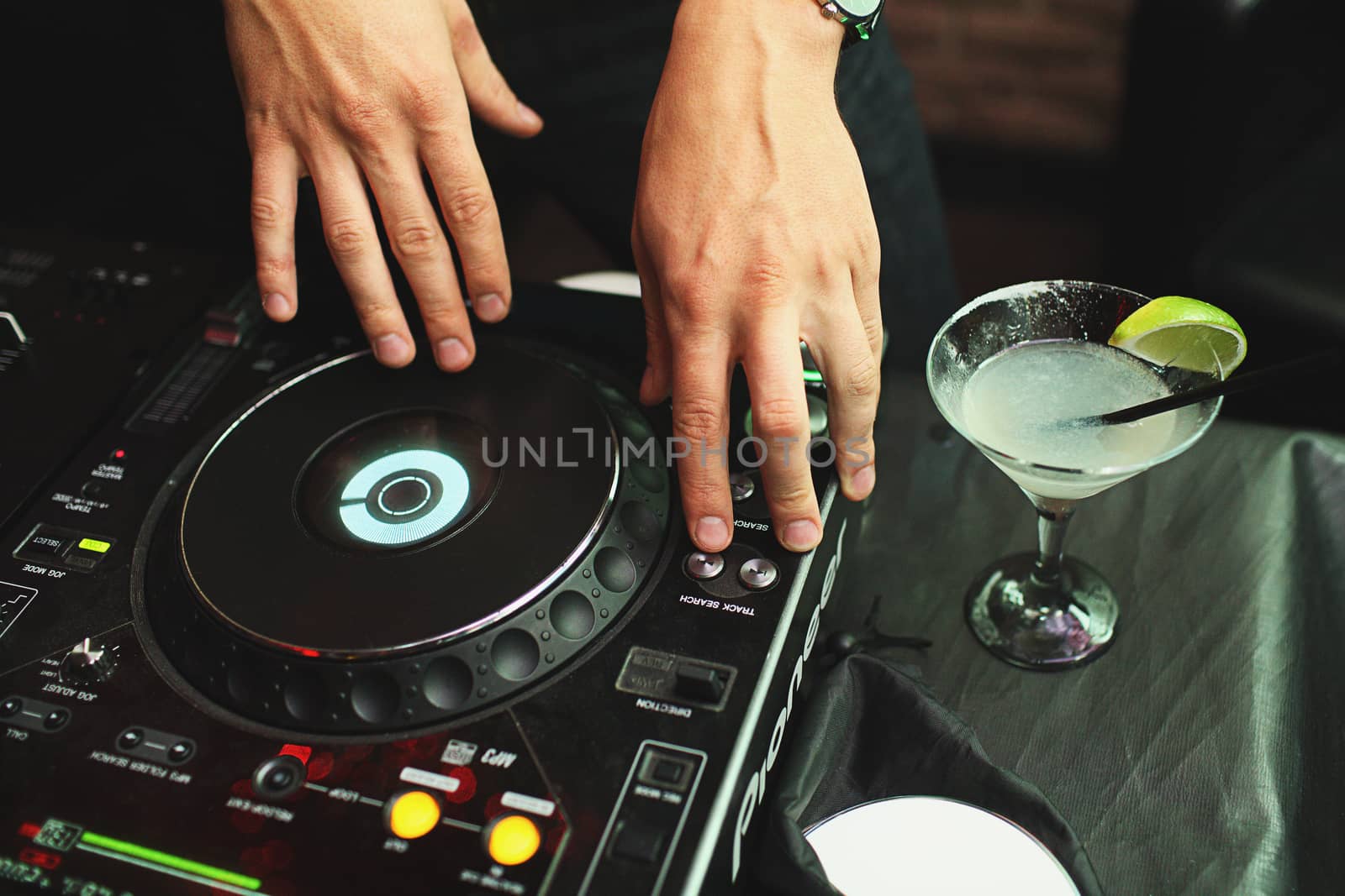 Hands of dj on vinyl playing music in night club