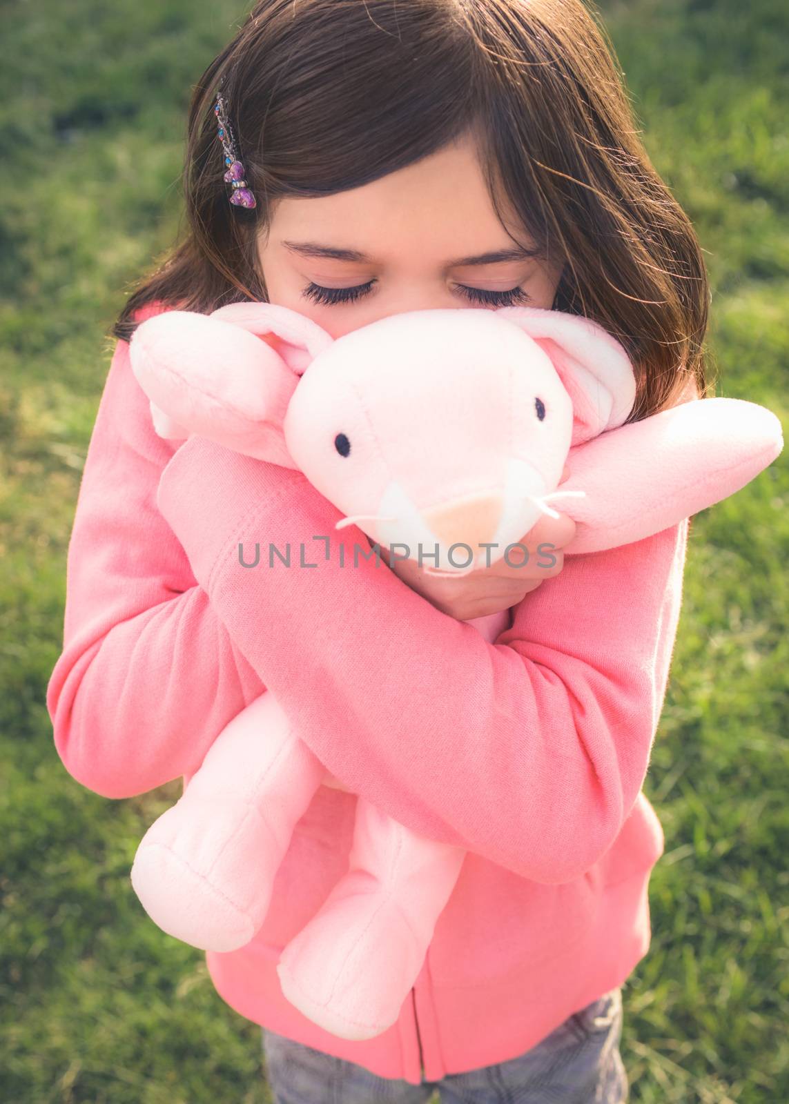 Young girl with brown hair is playing outside.