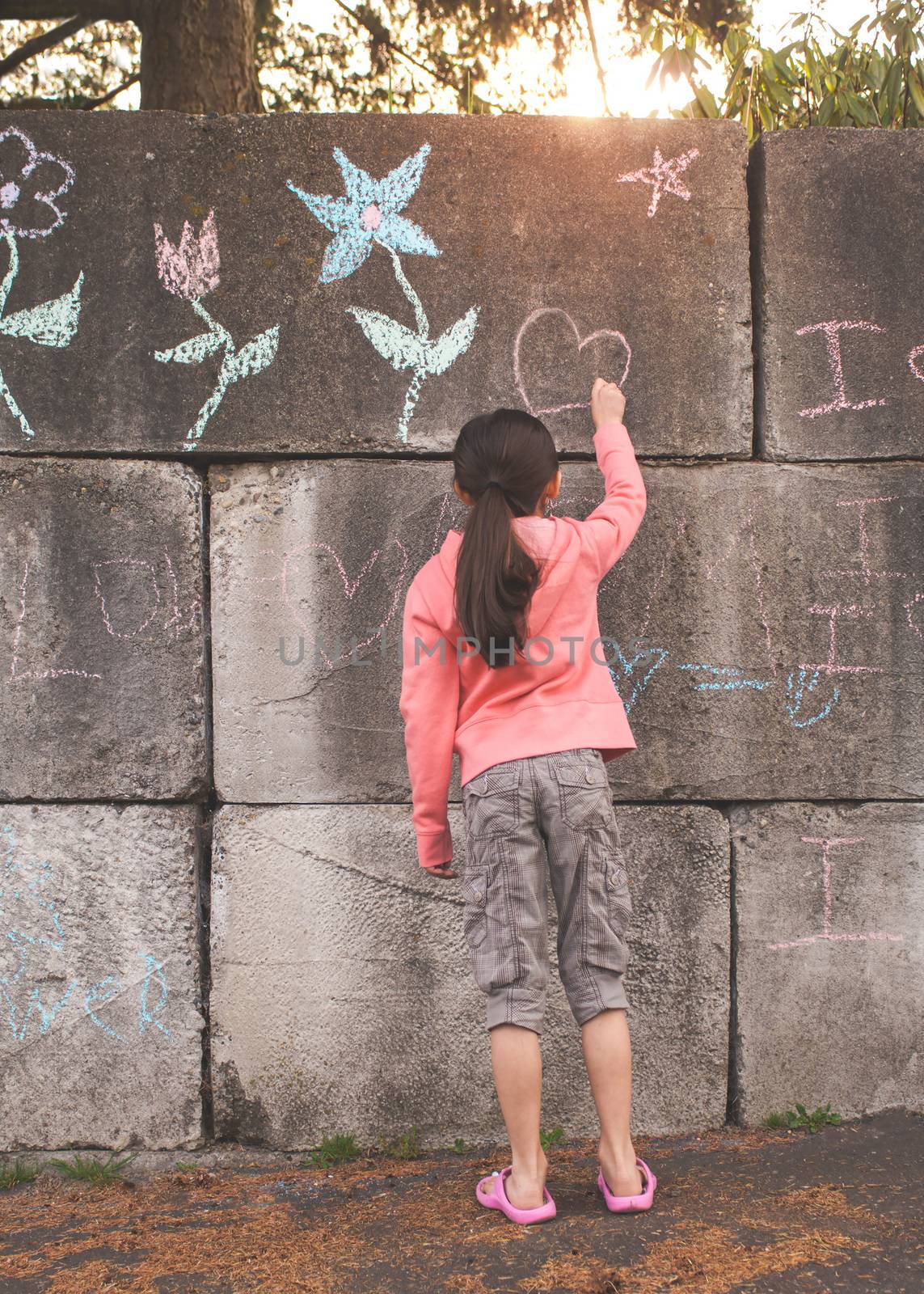 Young girl with brown hair is playing outside.