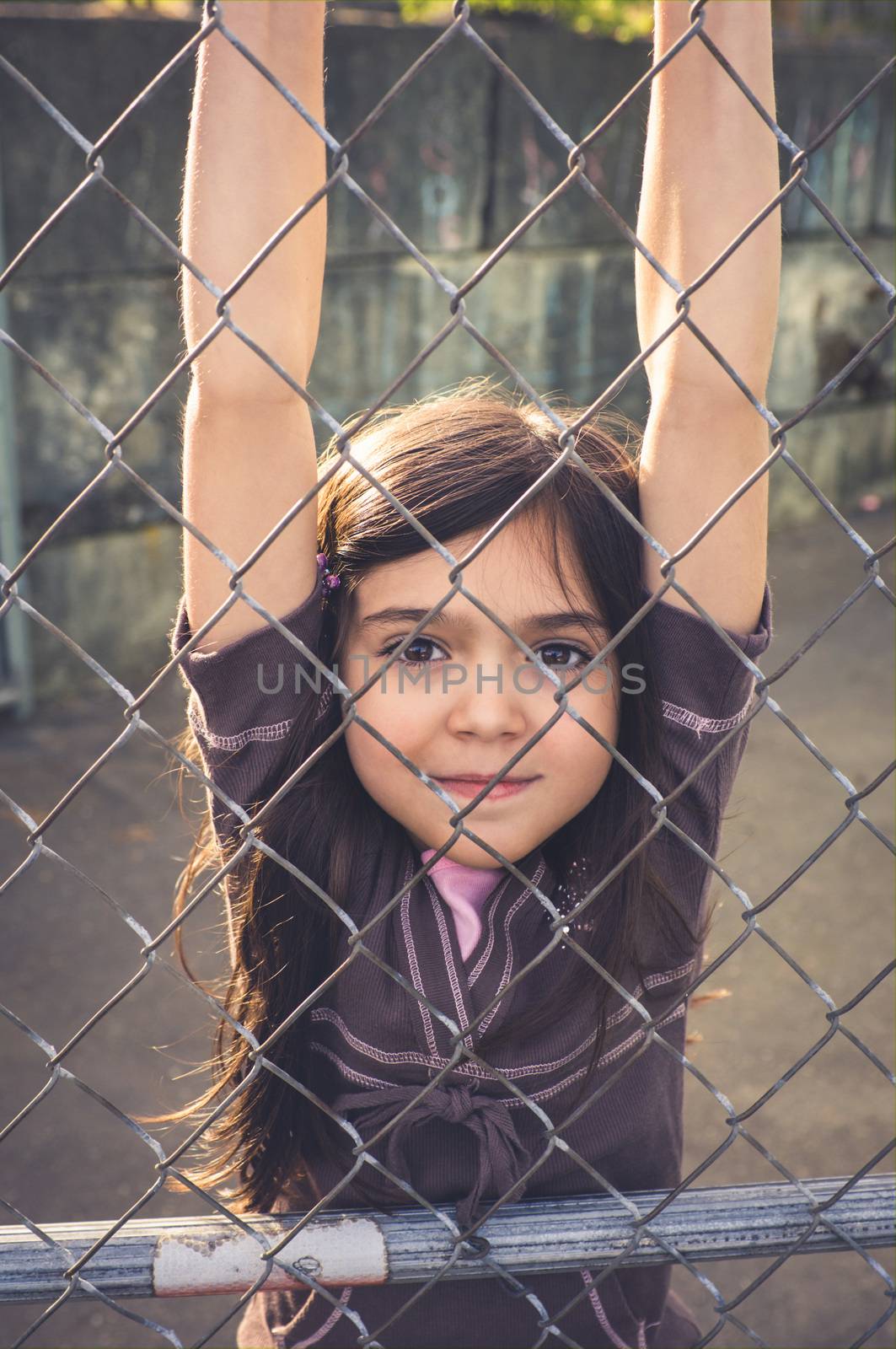 Young girl with brown hair is playing outside.