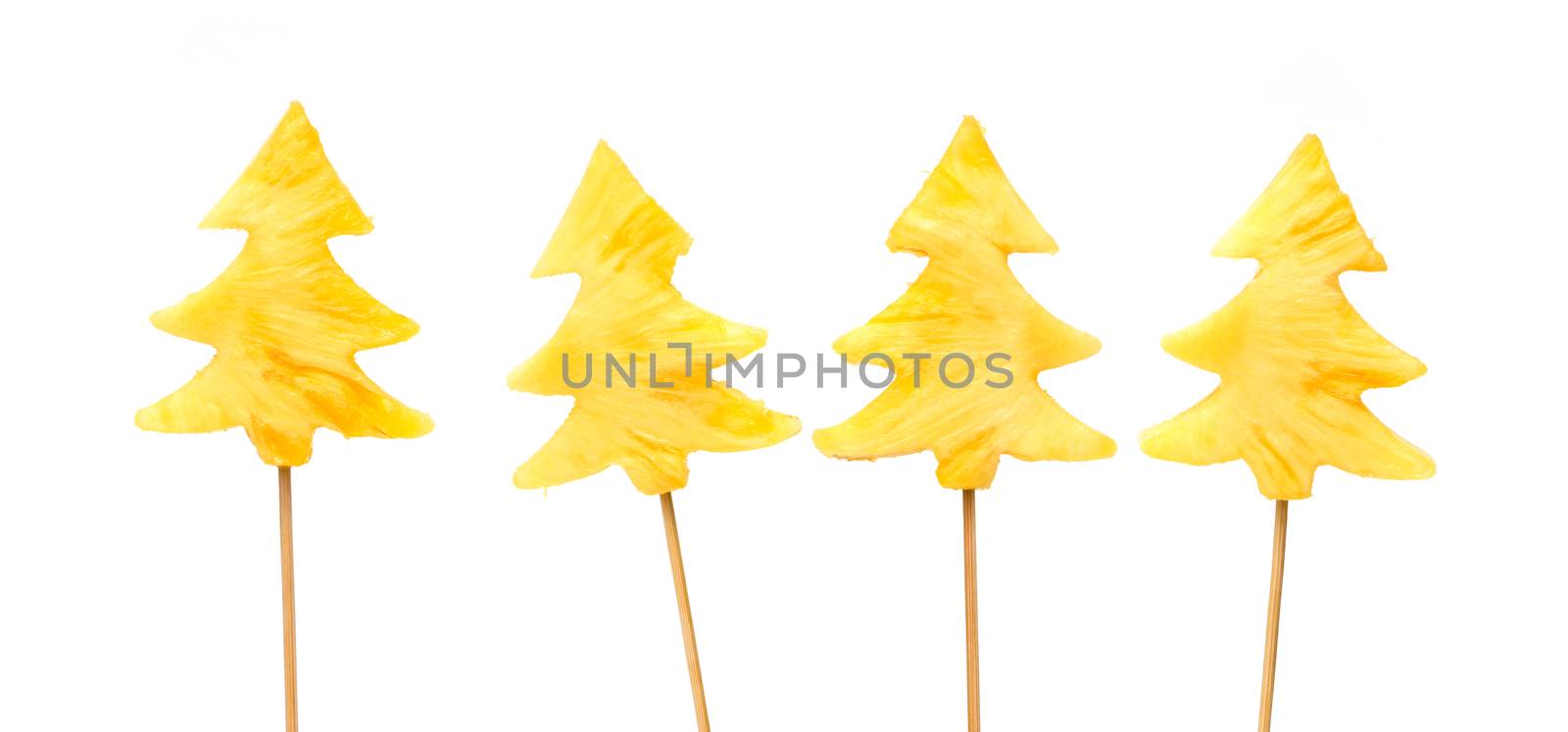 Fresh, raw pineapple chunks nailed on wooden stick isolated over white background