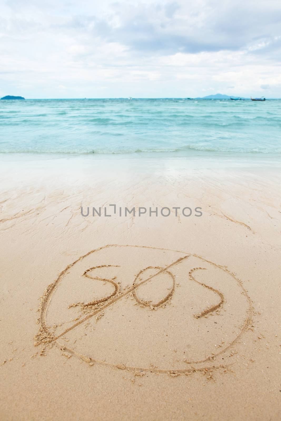 Safety on beach concept - inscription on a beach sand with coming wave
