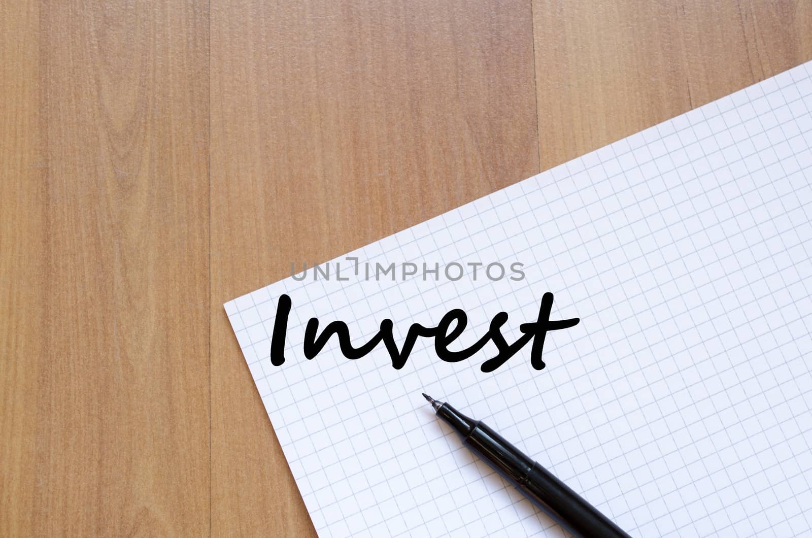 Invest text concept write on notebook with pen