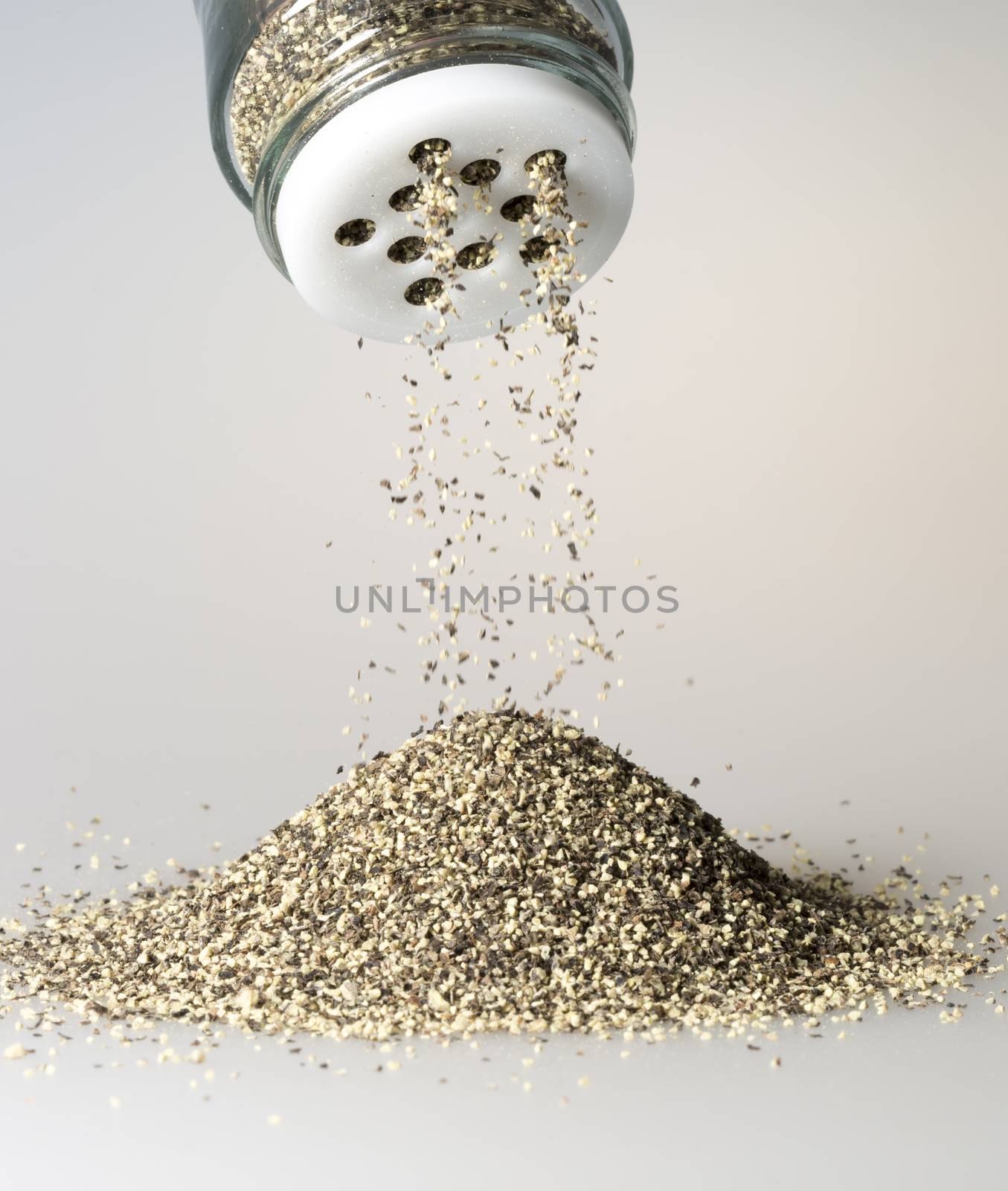 Black Pepper Grains Falling from shaker.