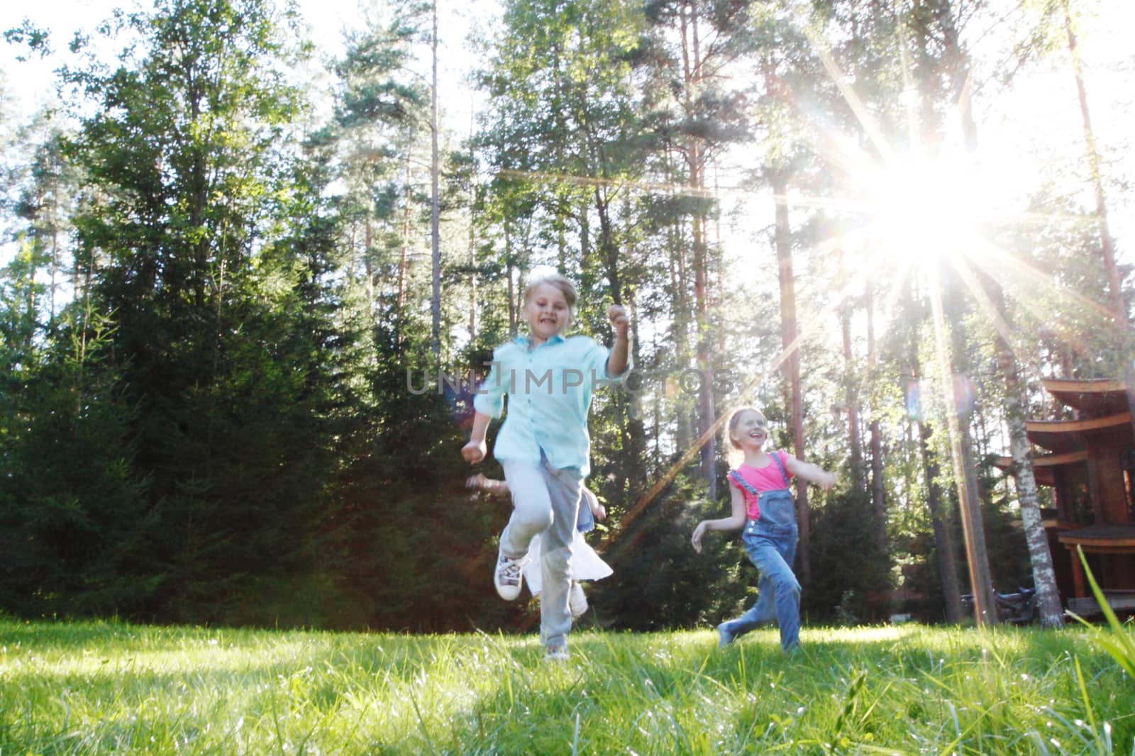 Group of young children running towards camera in park