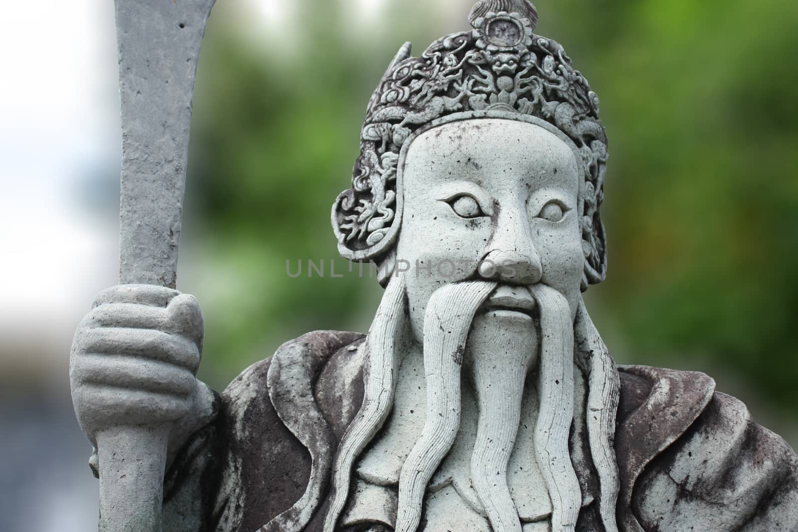 Chinese stone doll with blur green trees background