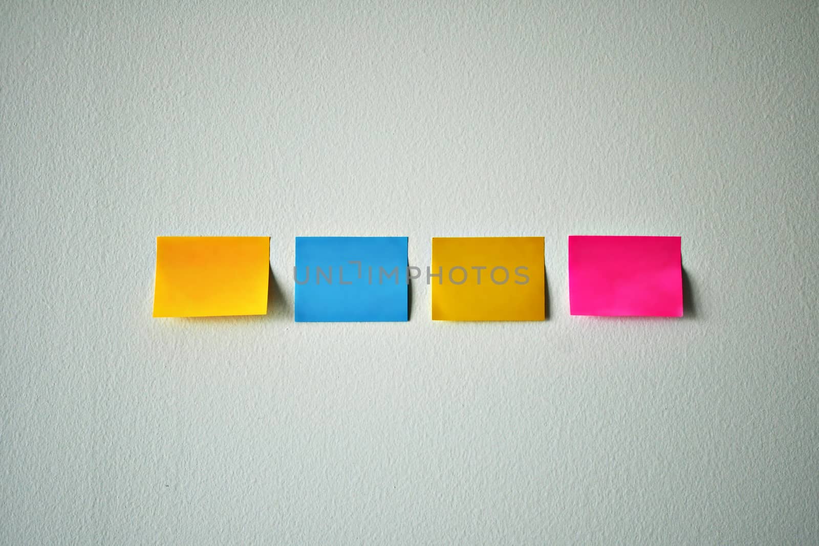 Multi-color sticky note on the white wall