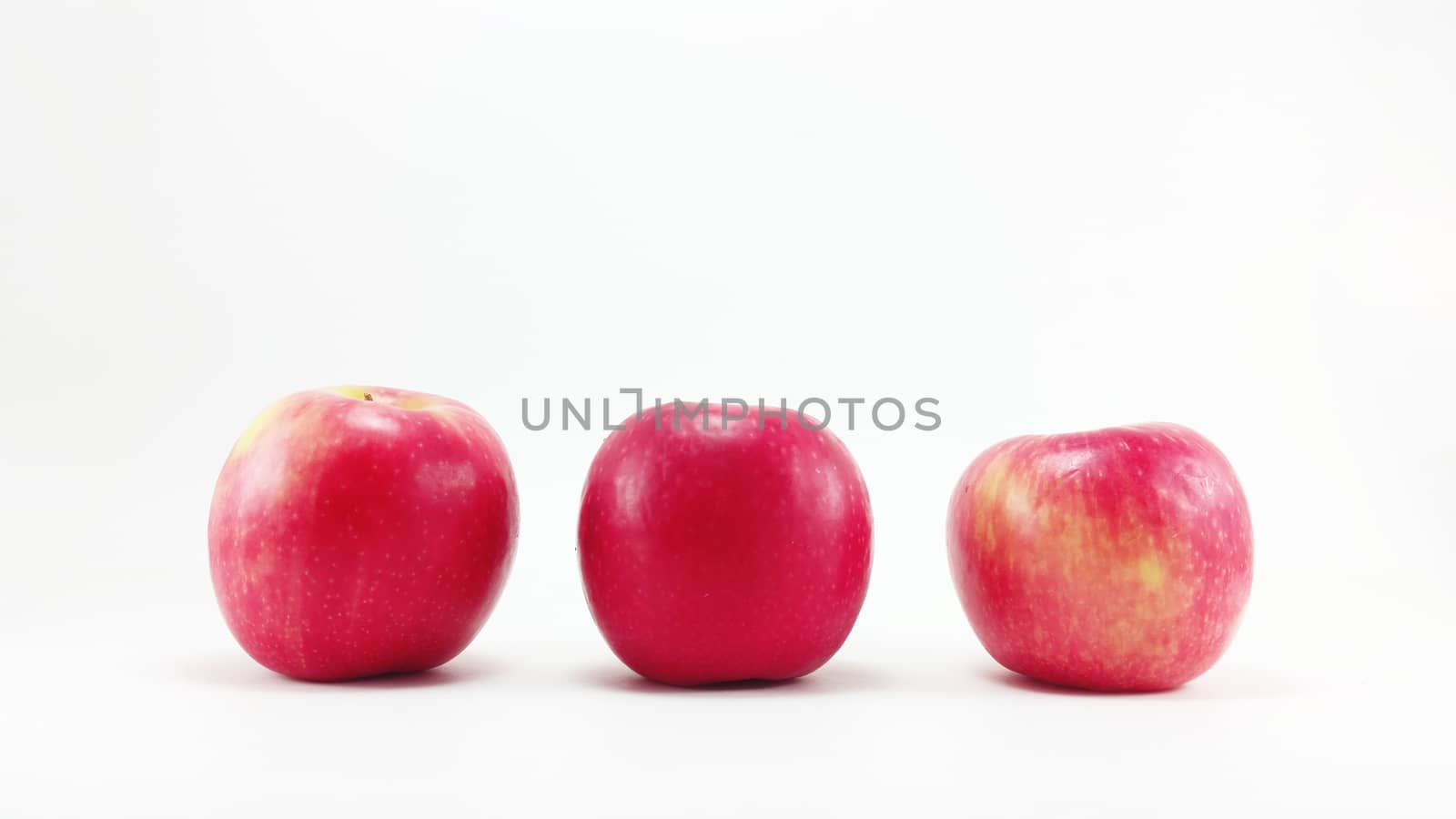 3 red apples in the row in white background
