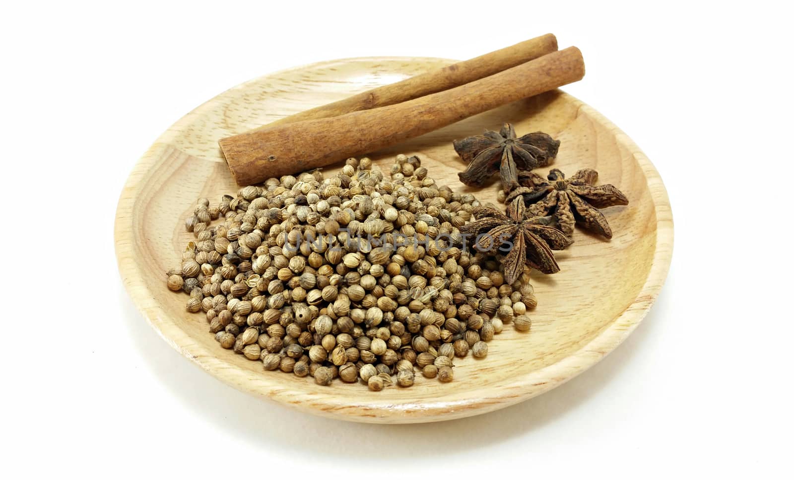 mixed spice (cinnamon, coriander seed, star anise) on wooden plate