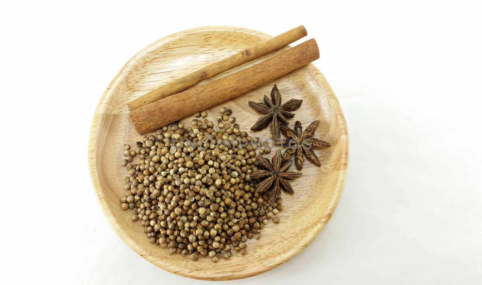 mixed spice (coriander seed, star anise, cinnamon) on wooden plate