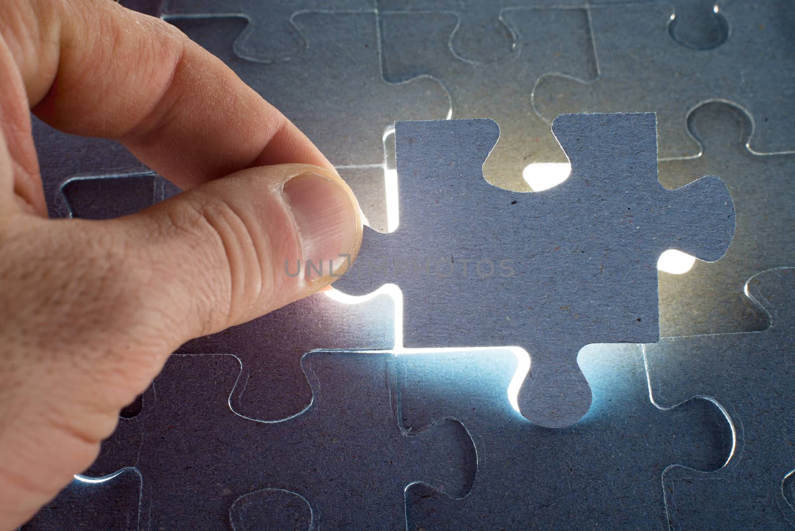 Missing jigsaw puzzle piece with light glow, for completing the final puzzle piece