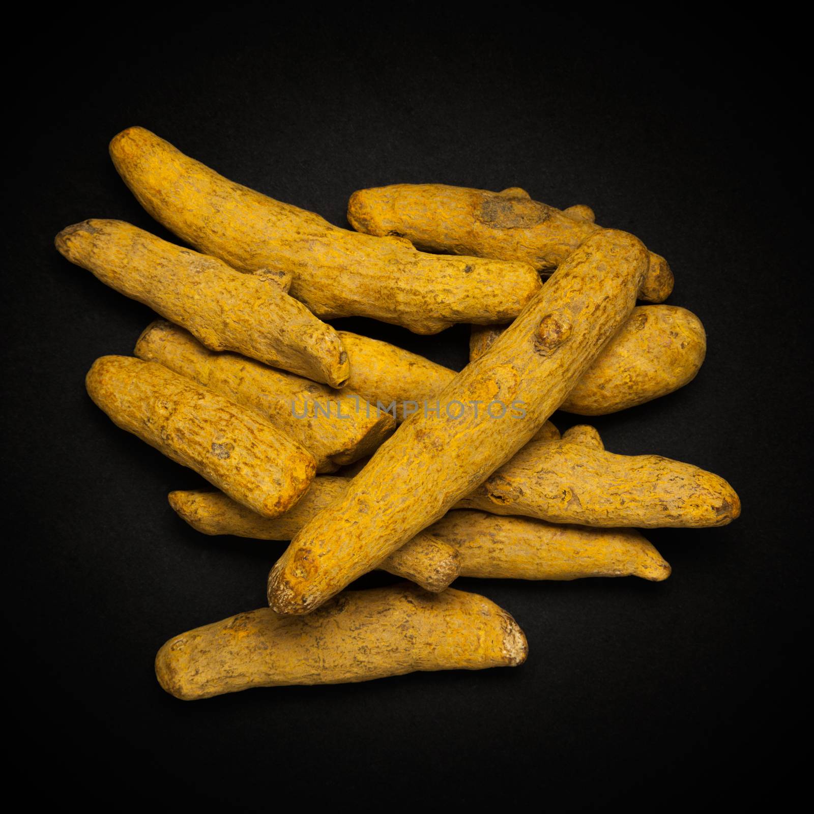 Top view of Organic Long Turmeric or Haldi (Curcuma longa) isolated on dark background.