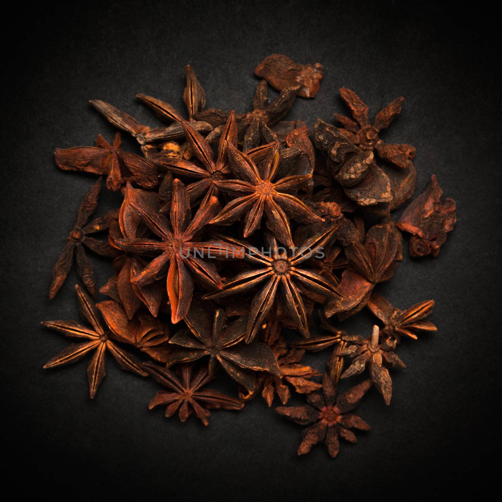 Top view of Organic Star anise or Chakra Phool (Illicium verum) isolated on dark background.