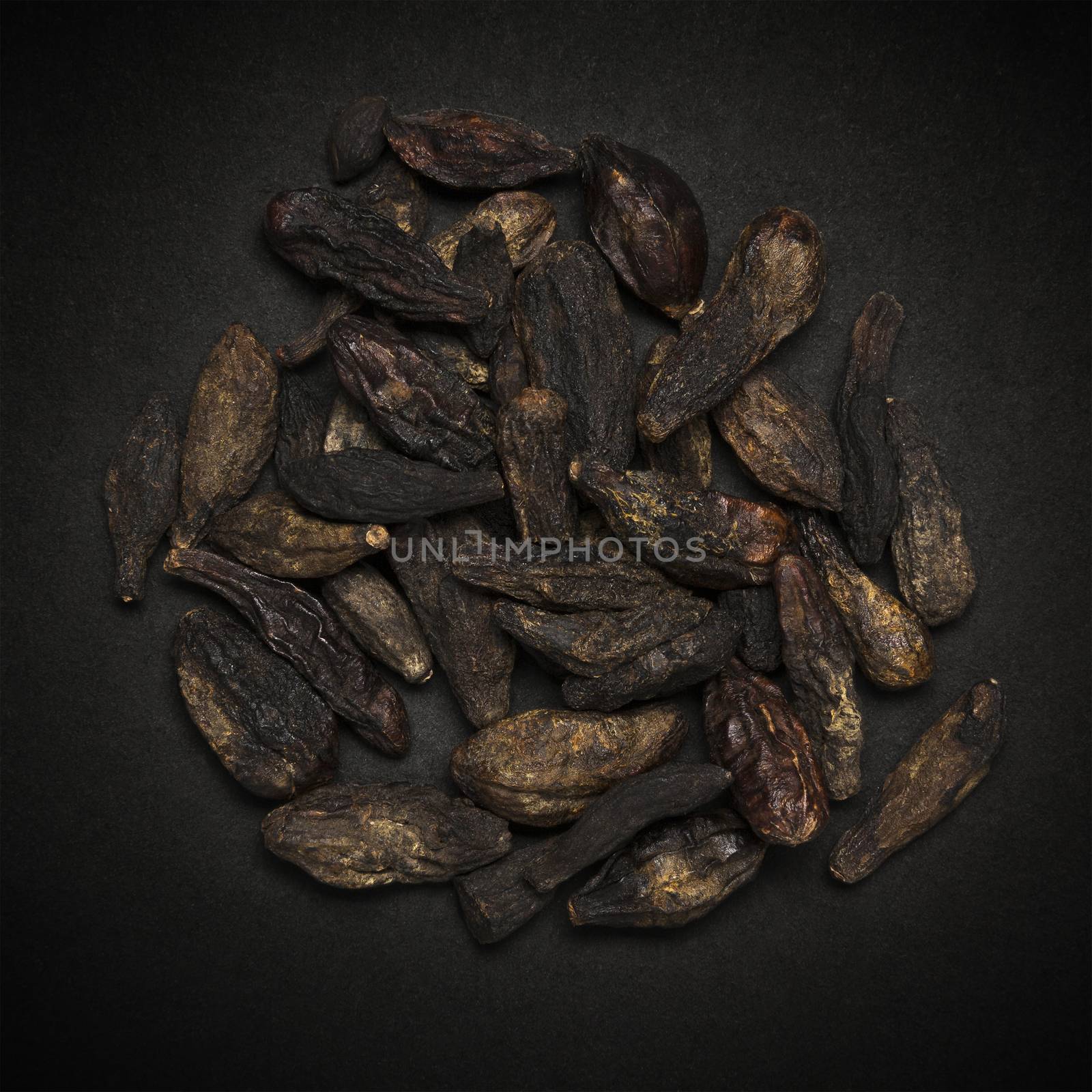 Top view of Organic Chebulic Myrobalan or Choti Harad (Terminalia chebula) isolated on dark background.