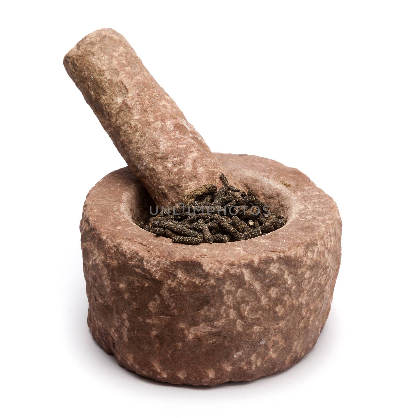 Organic Long pepper Dried Fruit (Piper longum) in mortar with pestle, isolated on white background.